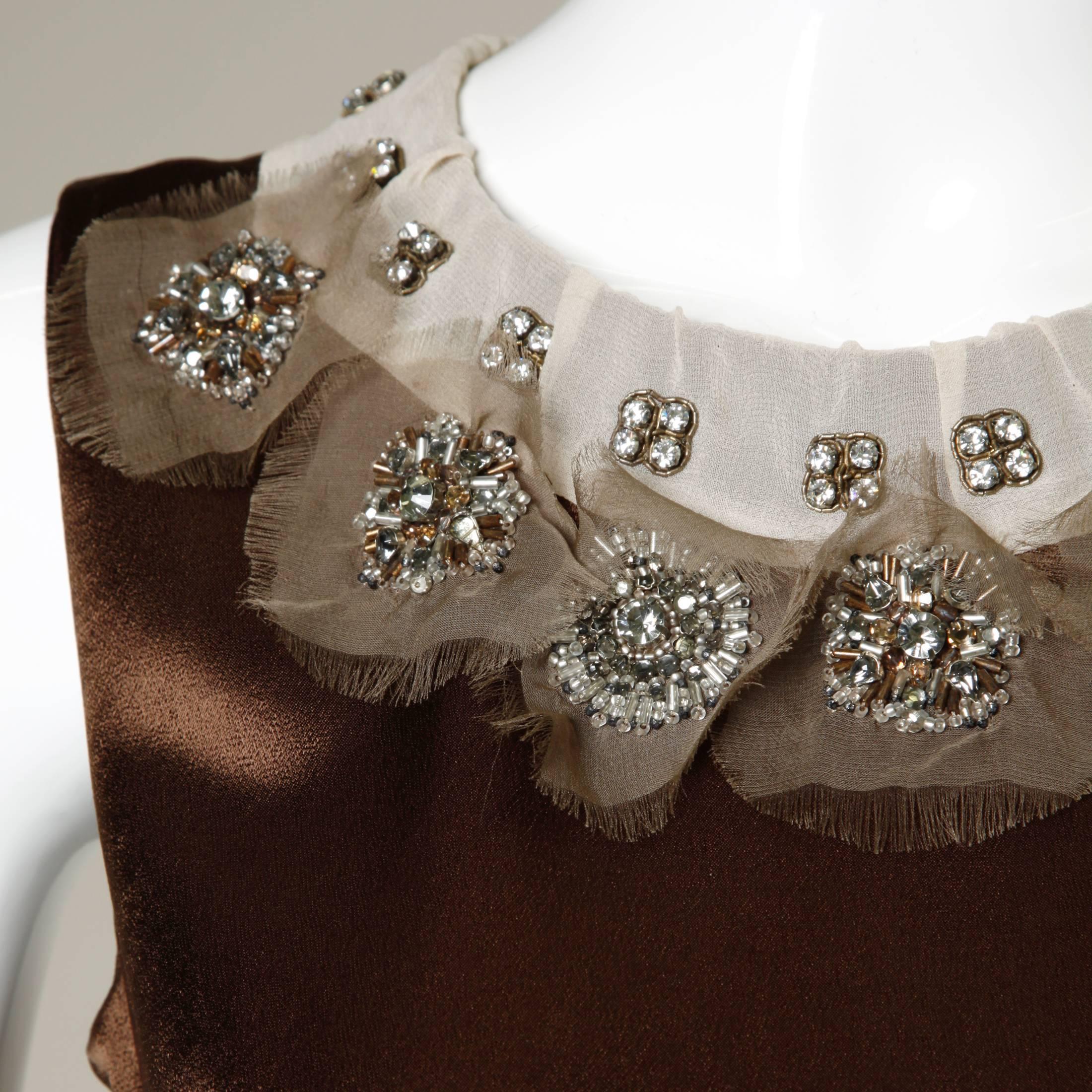 Gorgeous brown silk sleeveless top with a stunning neutral silk collar. The top is embellished with Swarovski crystal rhinestones and glass beadwork. Beautiful!

Details:

Unlined
Back Metal Zip Closure
Marked Size: T34
Estimated Size: