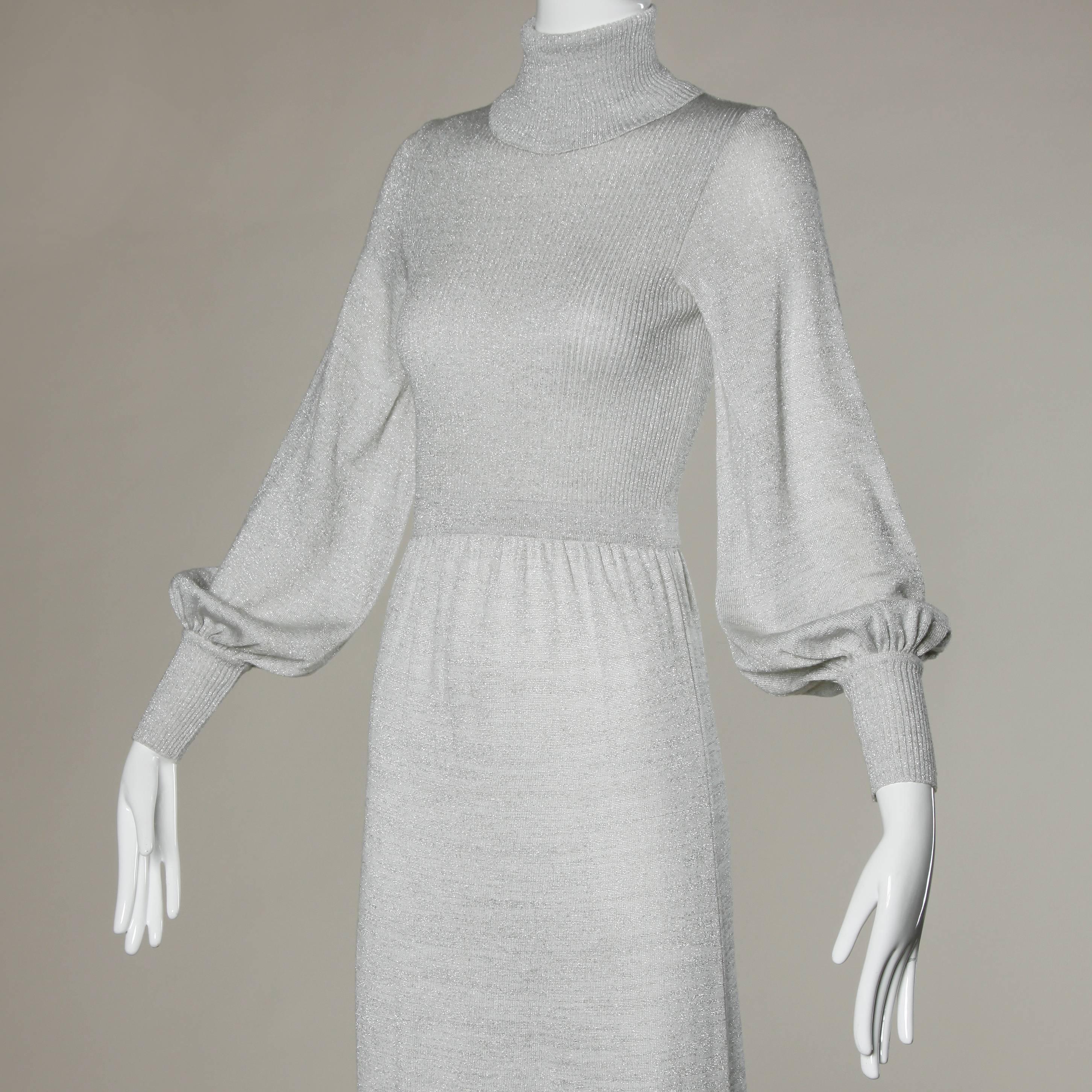 Vintage 1970s metallic silver knit maxi dress with billowy sleeves and a turtleneck collar.

Details:

Unlined
Back Zip Closure
Marked Size: US 5
Estimated Size: Small
Color: Silver Metallic
Fabric: 66% Acrylic/ 30% Wool/ 4% Lurex
Label: