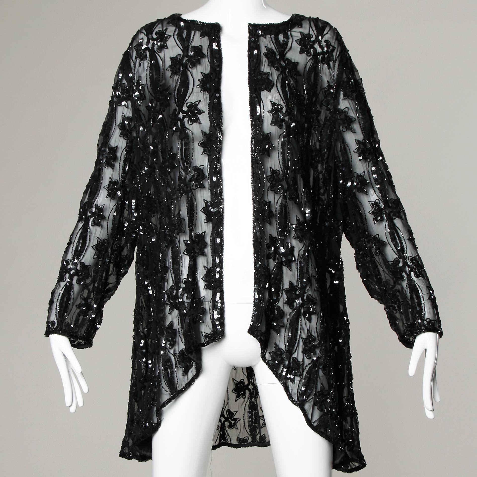 Gorgeous vintage sheer delicate silk chiffon duster jacket or coat with sequin and beadwork.

Details:

Unlined
Single Front Hook Closure
Marked Size: Large
Estimated Size: Free (Oversized Fit)
Color: Black
Fabric: 100% Silk
Label: Judith
