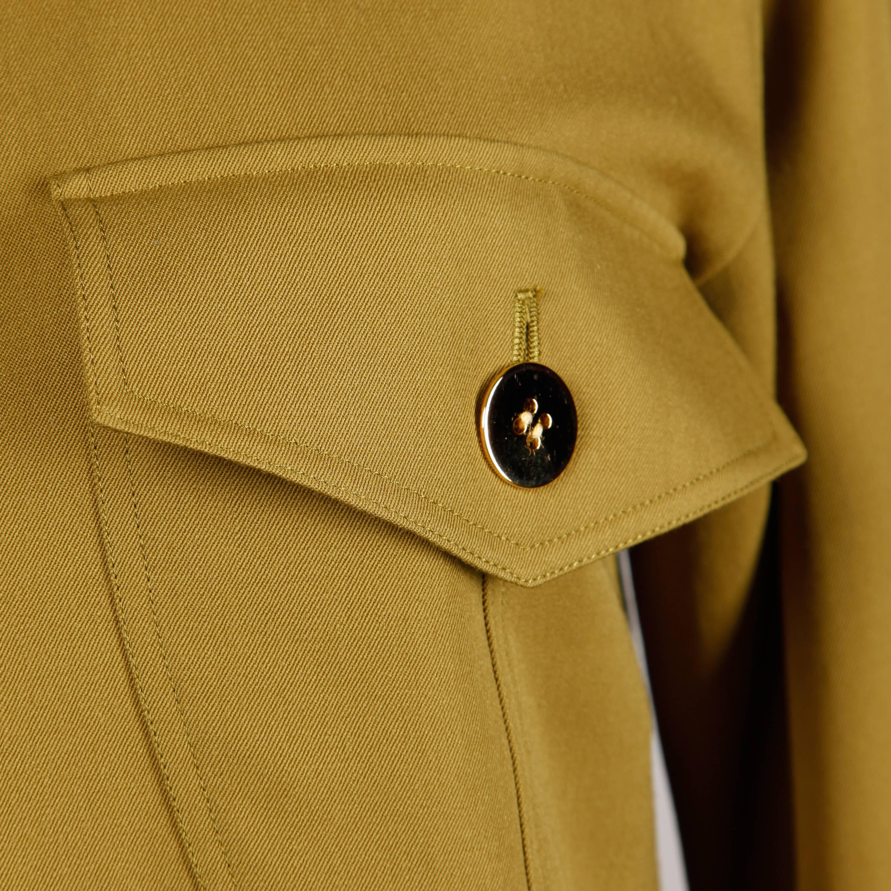Simple and chic olive green wool shirt dress by Genny. Designed by Gianni Versace. Shiny heavy brass buttons and beautiful construction.

Detail: 

Unlined
Pockets: 2 Front Square Pockets
Closure: Button Front (4)
No Marked Size
Estimated