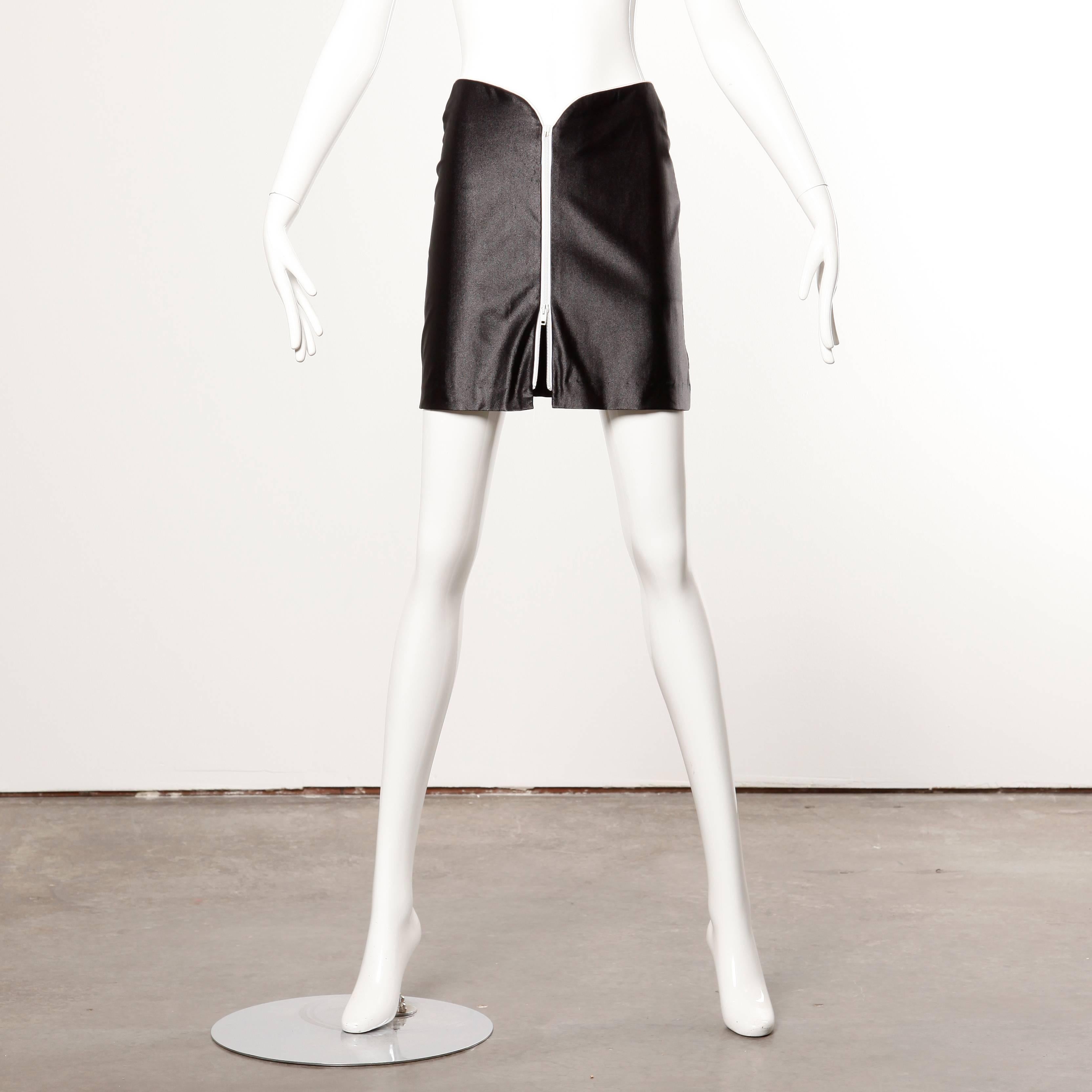 Iconic 1970s vintage shiny wet look disco zip up mini skirt by Le Gambi.

Details: 

Unlined
Zip Front Closure
Marked Size: 9/10
Estimated Size: Small
Color: Black/ White
Fabric: 85% Nylon/ 15% Lycra
Label: Le Gambi

Measurements: