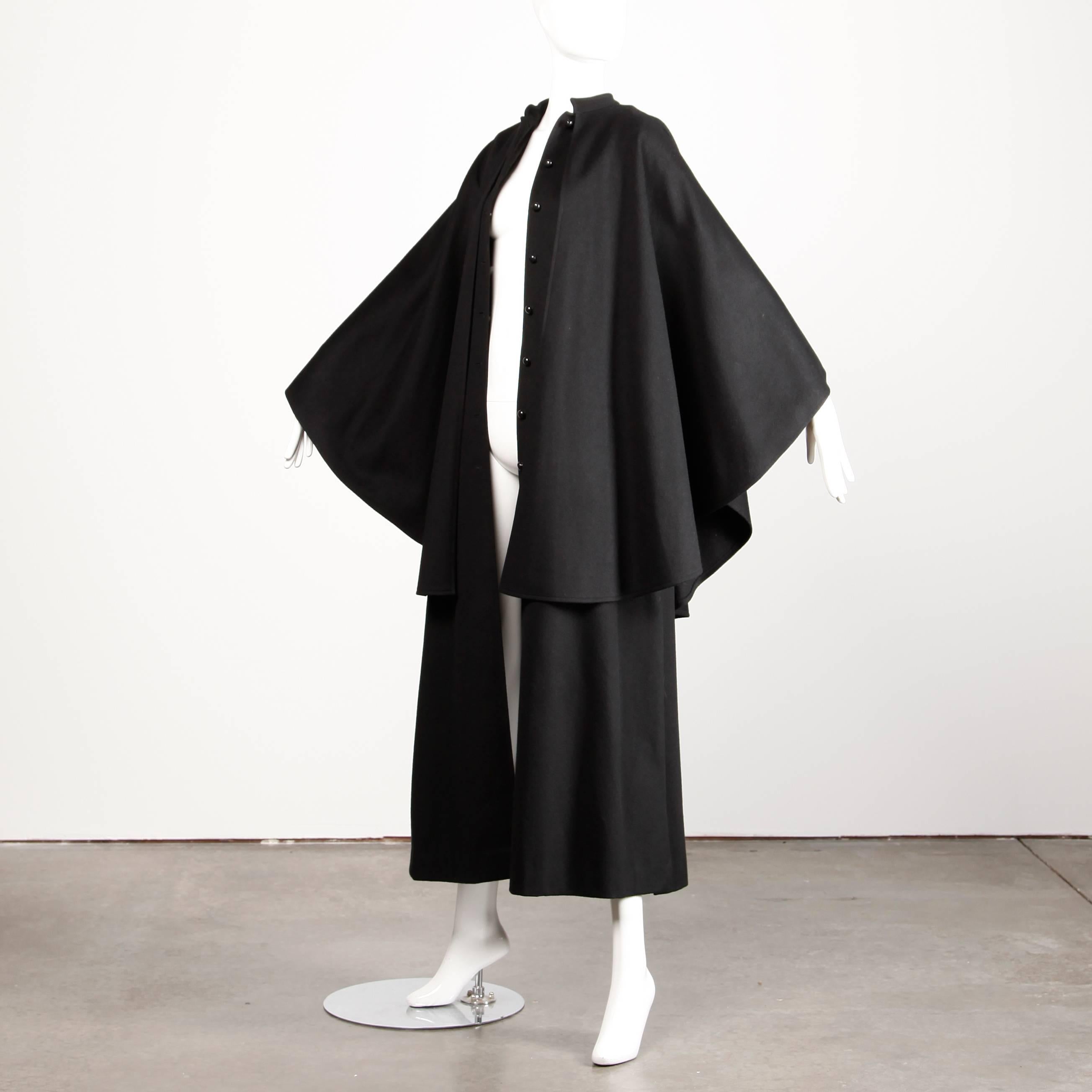 Completely amazing heavy black wool cape coat by Saint Laurent from the 1970s. The cape features two layers with giant batwing sleeves and front button closure. Long maxi length. Early Rive Gauche label.

Details: 

Unlined
Side Slit