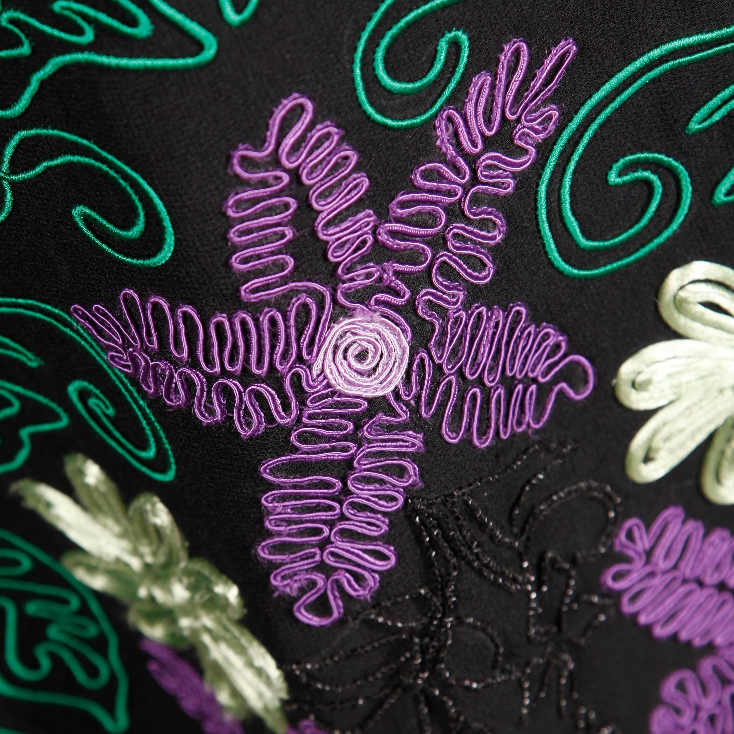 Stunning vintage black evening dress with purple, green and black embroidered flowers. Unique bust with plunging neckline and strap detail. By William Travilla.

Details: 

Fully Lined
Back Zip with Hook Closure
Marked Size: 12
Estimated