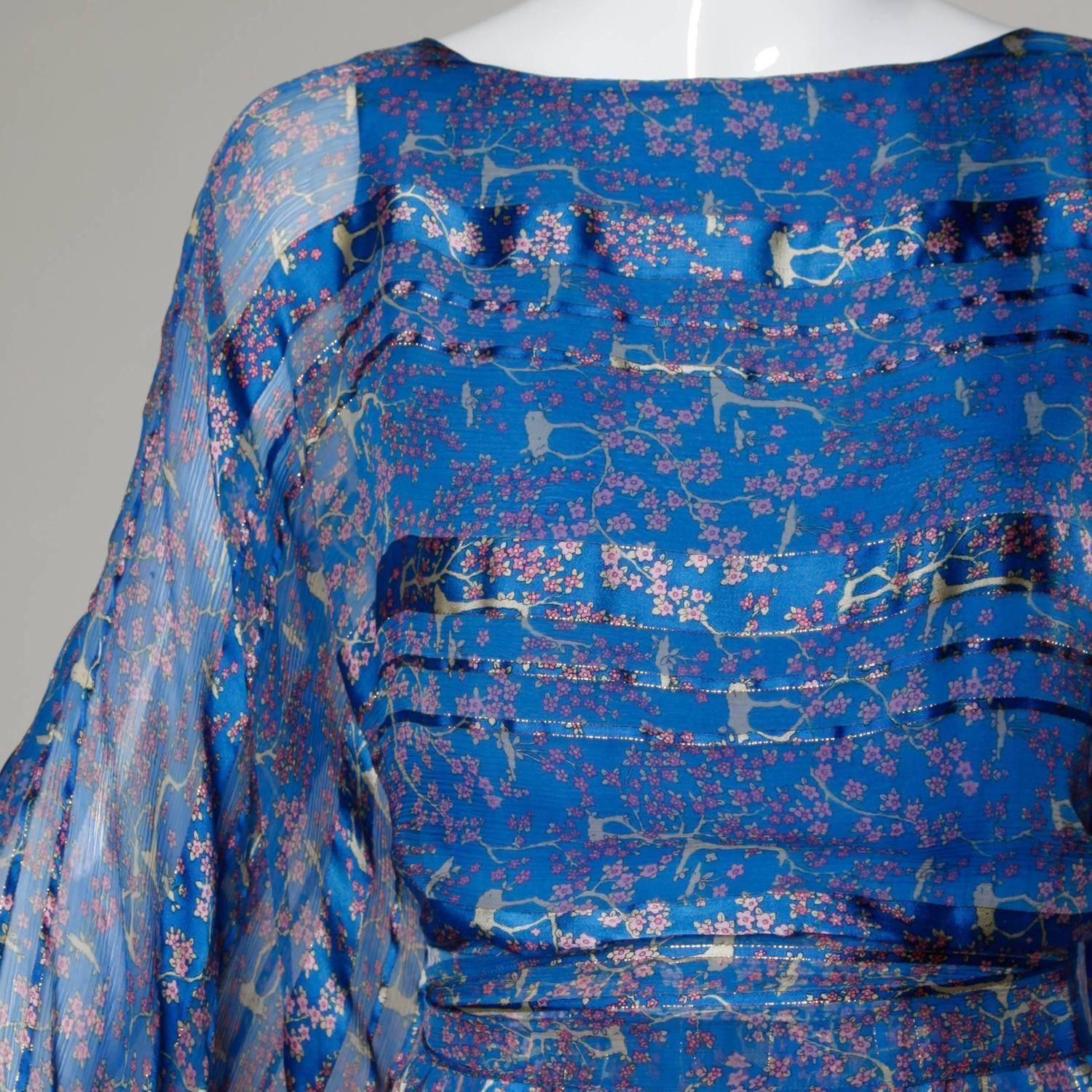 Delicate paper thin silk dress in shimmery blue with a cherry blossom floral print, huge billowy batwing sleeves and matching sash. The fabric on this dress is completely amazing!

Details: 

Fully Lined
Top Back Button Closure
Marked Size: