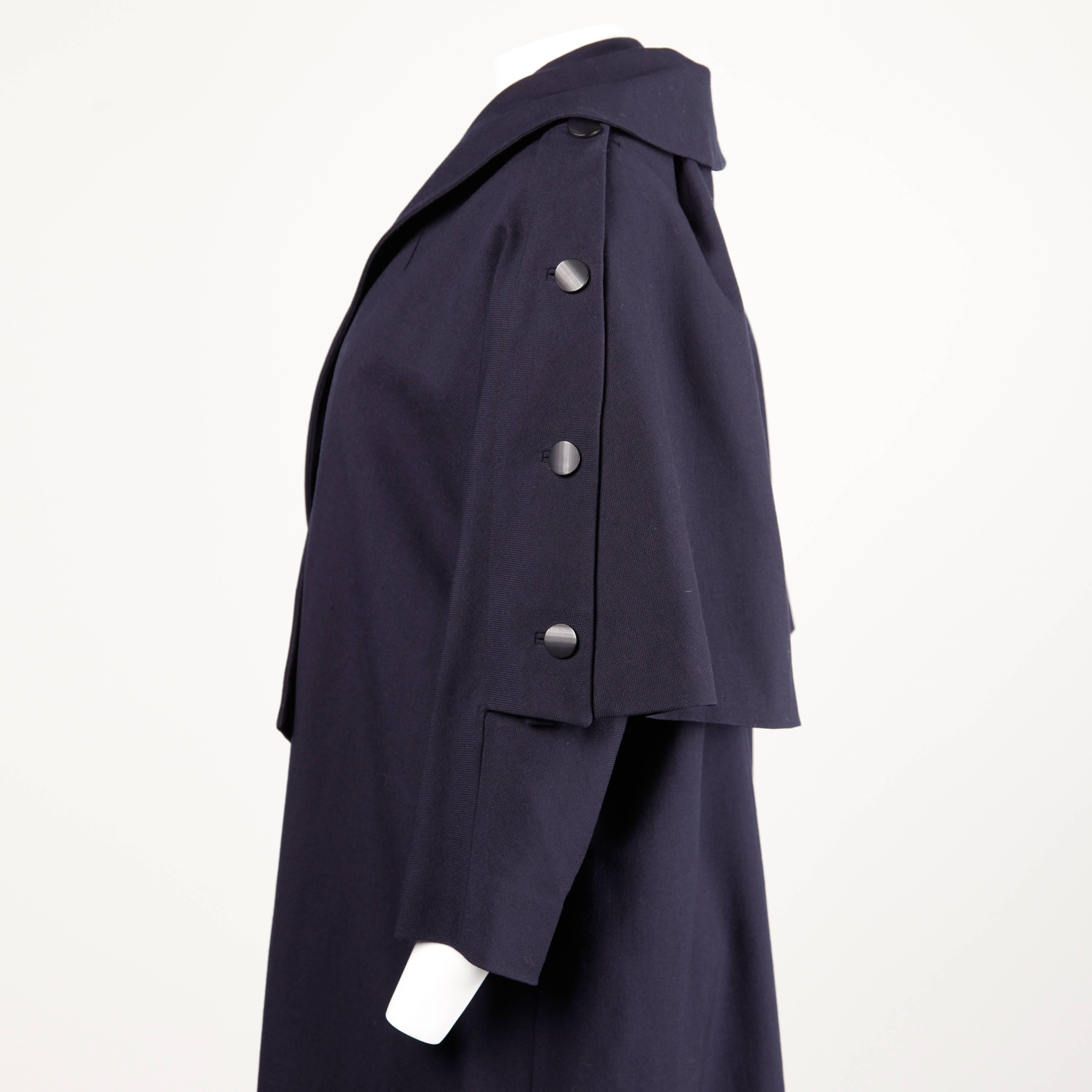 Stunning vintage 1950s coat by Jacques Heim in navy silk and wool. The coat has a unique cut with a back cape/ scarf piece that buttons on and off. Wear this coat different ways! Beautiful construction with hand stitched detailing throughout, bound
