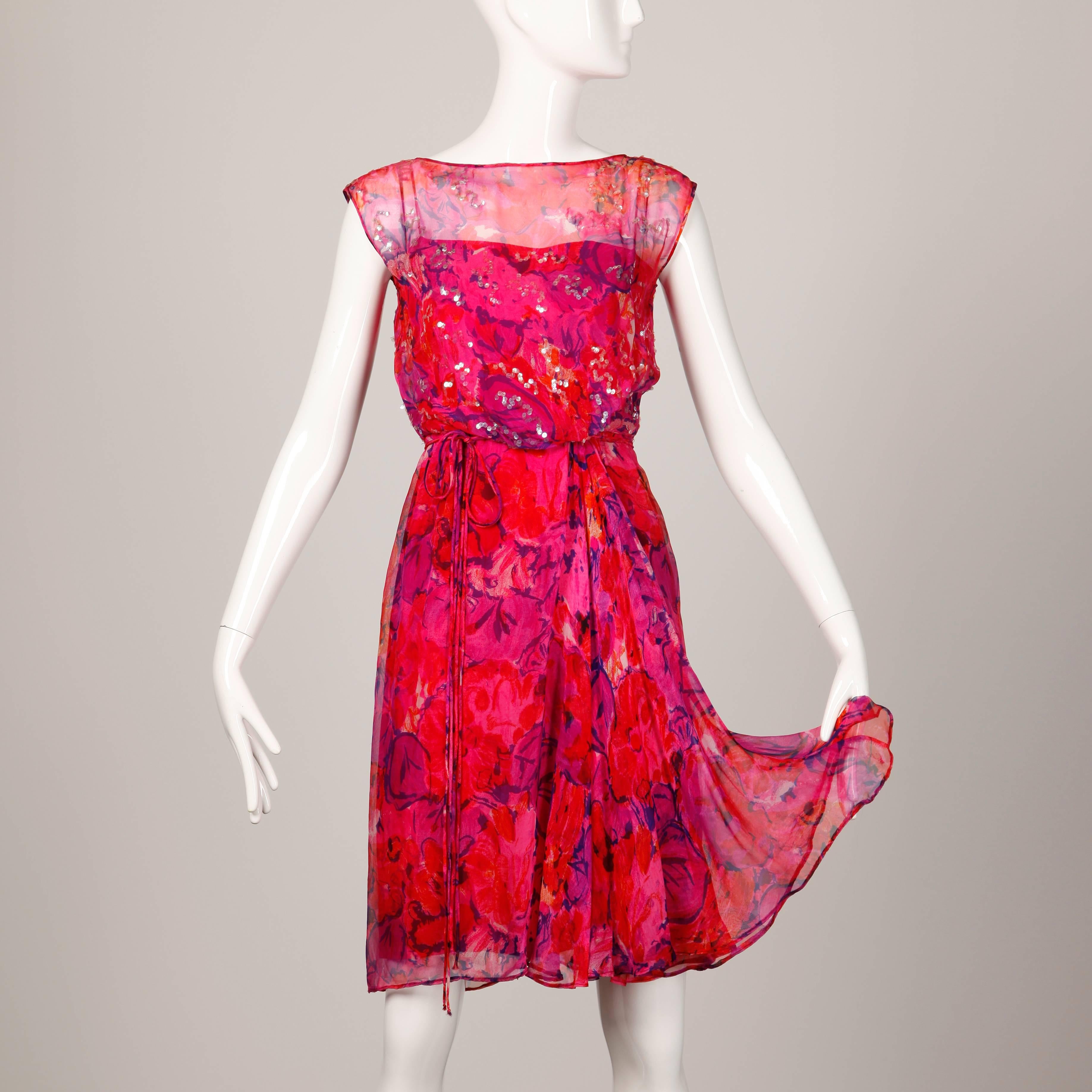 Beautiful delicate tissue silk chiffon cocktail dress in a vibrant floral print. Clear sequin embellishment and matching waist tie.

Details: 

Fully Lined
Back Metal Zip with Hook and Eye Closure
Marked Size: Unmarked
Estimated Size: XS-