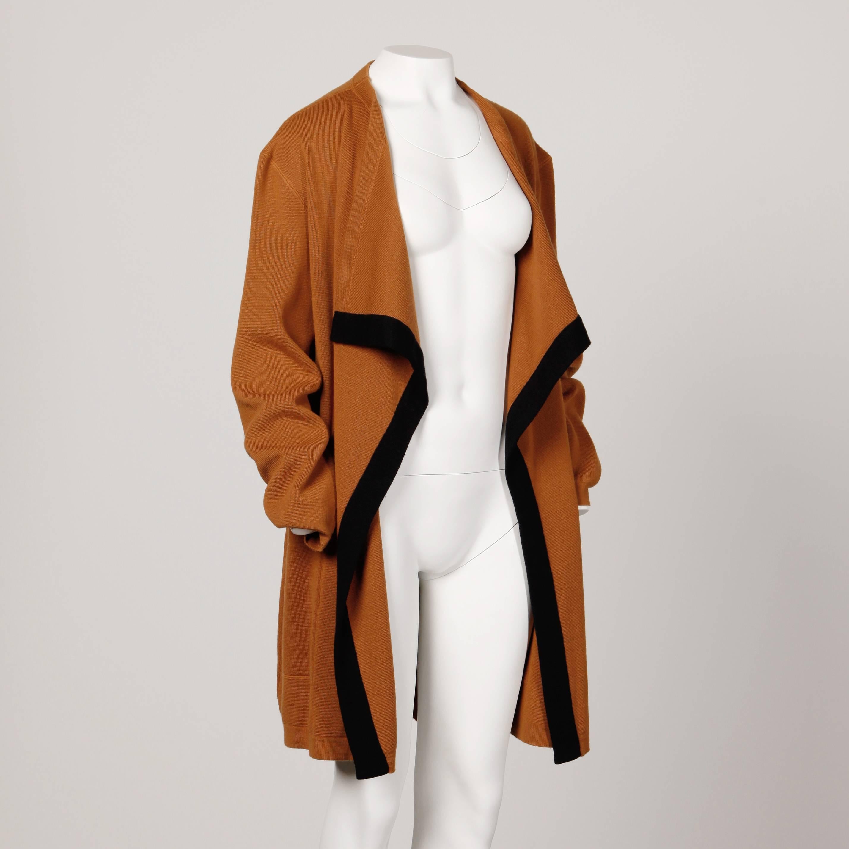 Oversized vintage two-tone wool knit cardigan sweater coat by Courreges. Avant garde shape with draped front. A great layering piece!

Details: 

Unlined
Front Box Pockets
Estimated Size: Free XS-XL
Color: Brown/ Black
Fabric: Wool