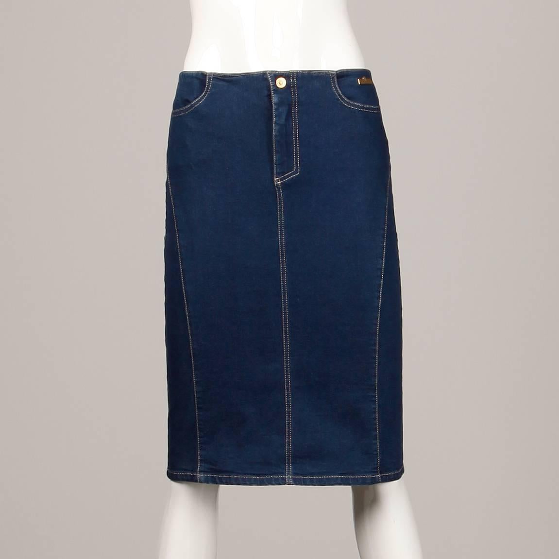 Low waisted Versace jean skirt made of dark stretch denim. Unlined with front zip and button closure. Two front pockets. 88% Cotton, 11% nylon, 1% other. The marked size is 30/44. The low waist measures 30", hips 34" and total length