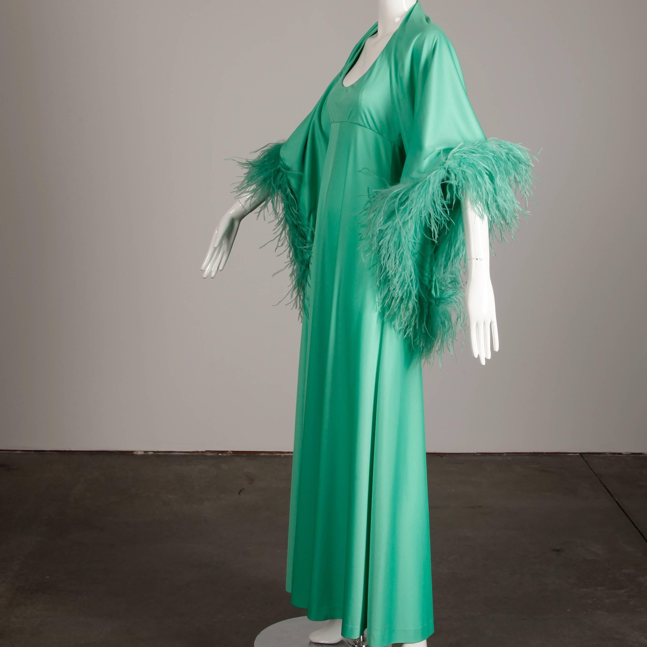 Vintage 2-piece ensemble by Joan Leslie by Kasper featuring a mint green jersey knit maxi dress with matching ostrich feather trimmed wrap. Partially lined with side zip and hook closure. The marked size is 10, but the ensemble fits like a modern