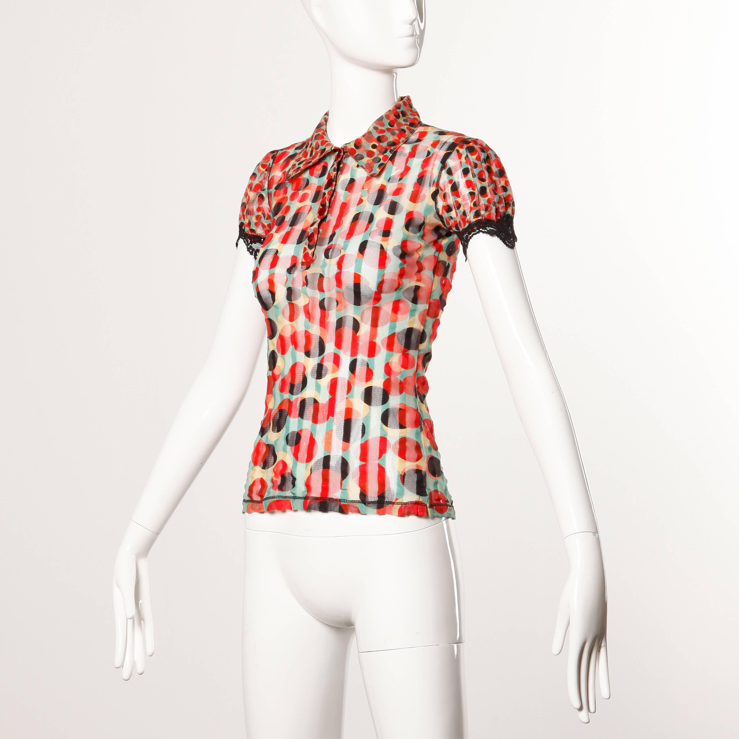 Vintage sheer mesh short sleeved top with lace trim and an op art polka dot print by Jean Paul Gaultier.

Details: 

Unlined
Front Button Closure
Marked Size: S
Color: Blue-Green/ Red/ Black/ Gold
Fabric: 100% Nylon
Label: Jean Paul