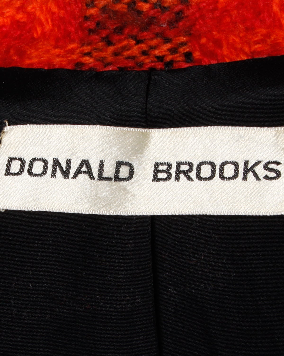 Wunderschönes tailliertes Karo-Sakko von Donald Brooks in einem lebhaften Karo. Bommelknöpfe aus schwarzem Leder und handgenähte Couture-Details. Mittelschwere Wolle.

Einzelheiten:

Vollständig
