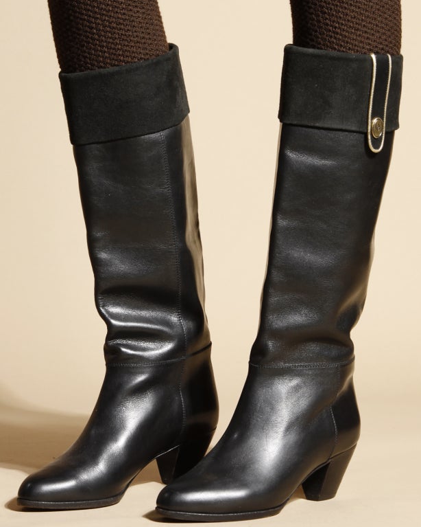Black leather riding boots by Christian Dior. All lined with beige leather lining. Christian Dior logo on the interior in gold embossed letters. Finished with suede cuffs and a tiny Dior brass logo on the side. Marked size 5. Stacked wooden heel.