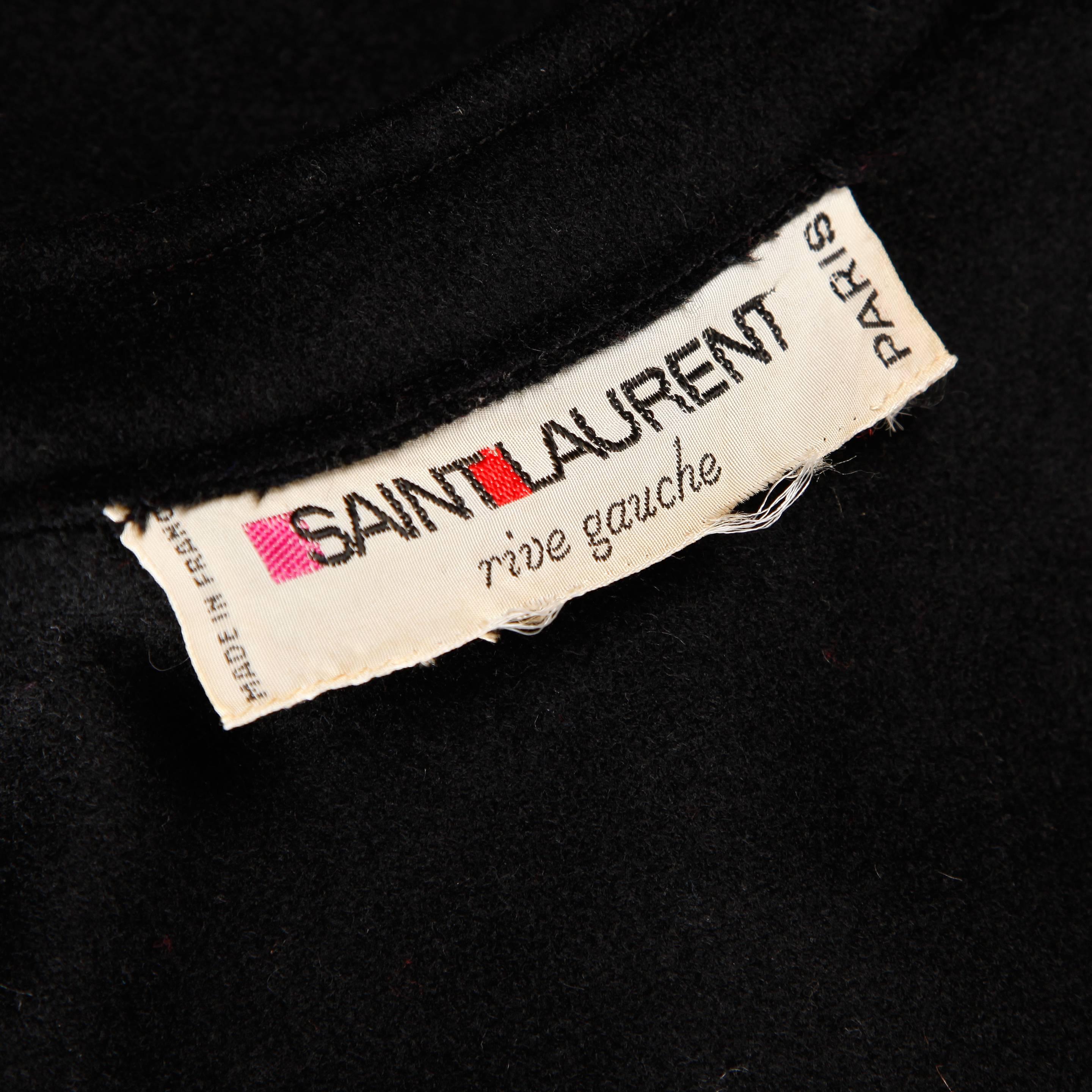 Completely amazing vintage heavy black wool cape coat by Yves Saint Laurent from the 1970s. The cape features two layers with giant bat wing sleeves and front button closure. Long maxi length. Early Yves Saint Laurent Rive Gauche label. Fits most