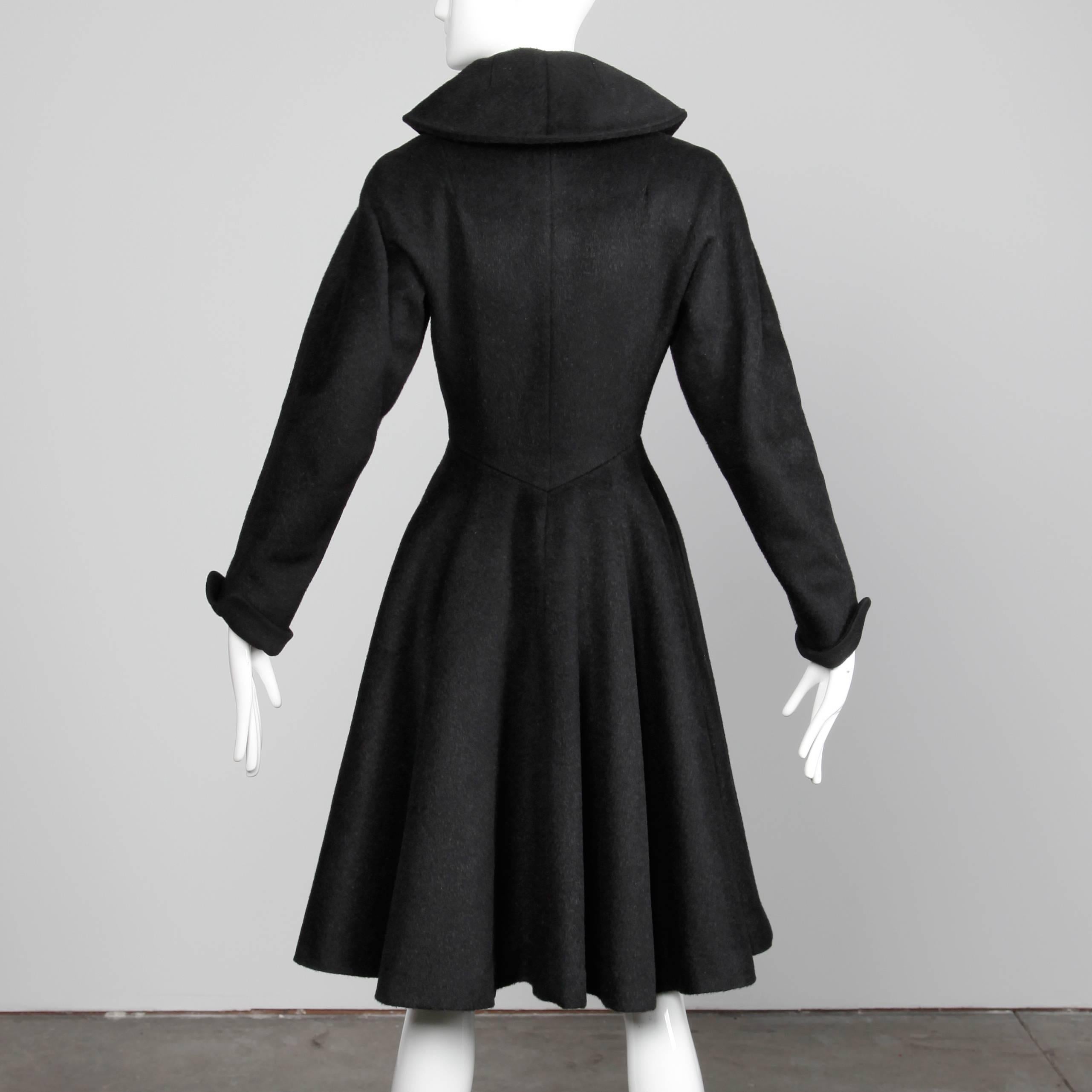 So much fabric in this heavy black wool coat from the 1950s! Full sweep and tiny nipped waist. Fully lined with front button closure. Hidden side pockets. 100% Wool. Fits like a modern size small. The bust measures 35