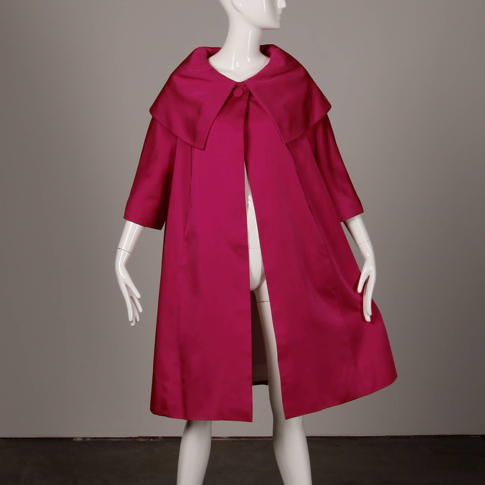 Stunning vibrant fuchsia silk satin swing coat with a giant pop up collar and full sweep by Sandra Sage. Fully lined with front button and snap closure. Hidden side pockets. Fits most sizes XS-XL due to the free shape. The bust measures 46