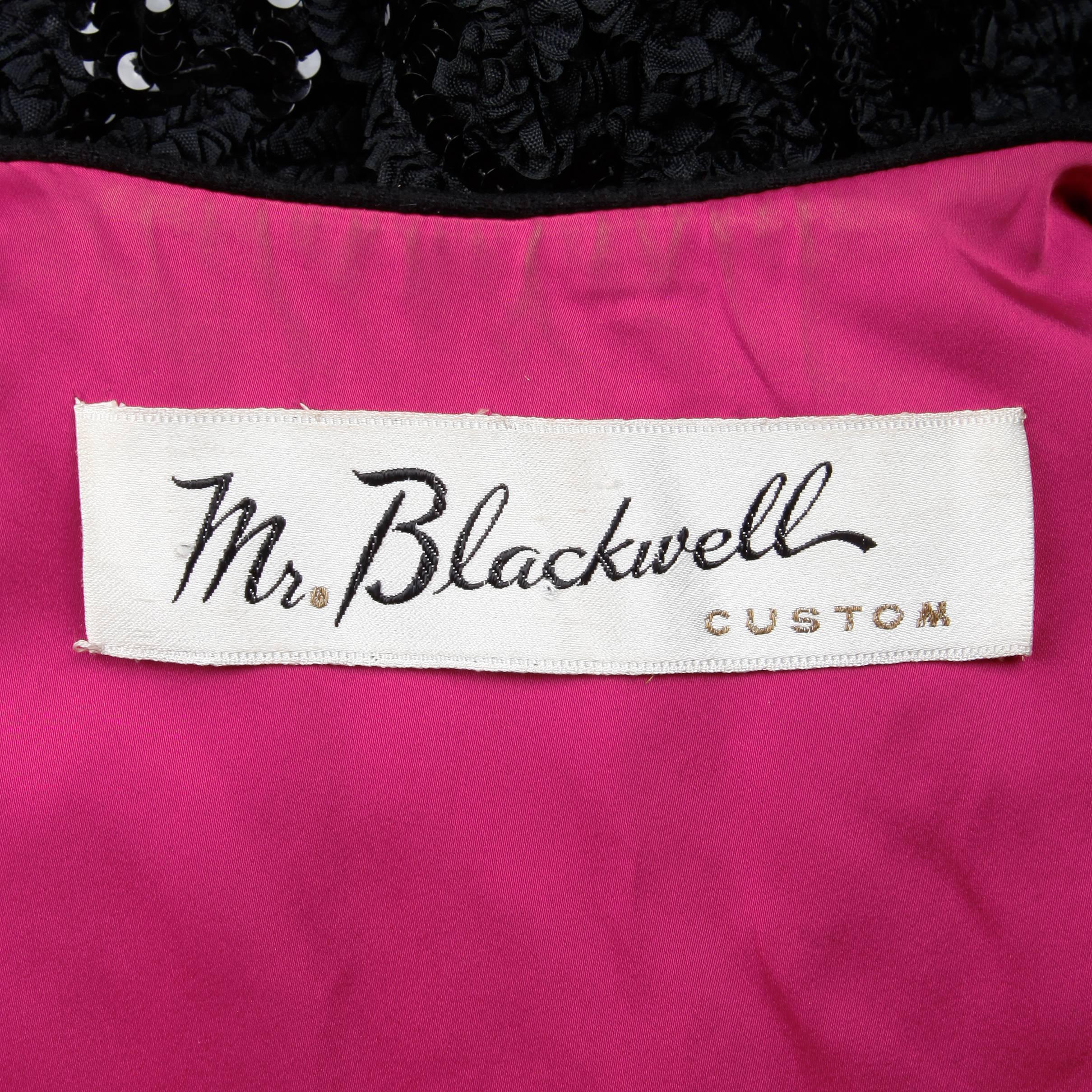 Wunderschöne schwarze Wollweste von Mr. Blackwell aus den 1960er Jahren mit schwarzer Pailletten- und Perlenstickerei am unteren Rand und leuchtend rosa Satinfutter. Vollständig gefüttert mit Hakenverschluss vorne. Freie Größe. Gesamtlänge 35