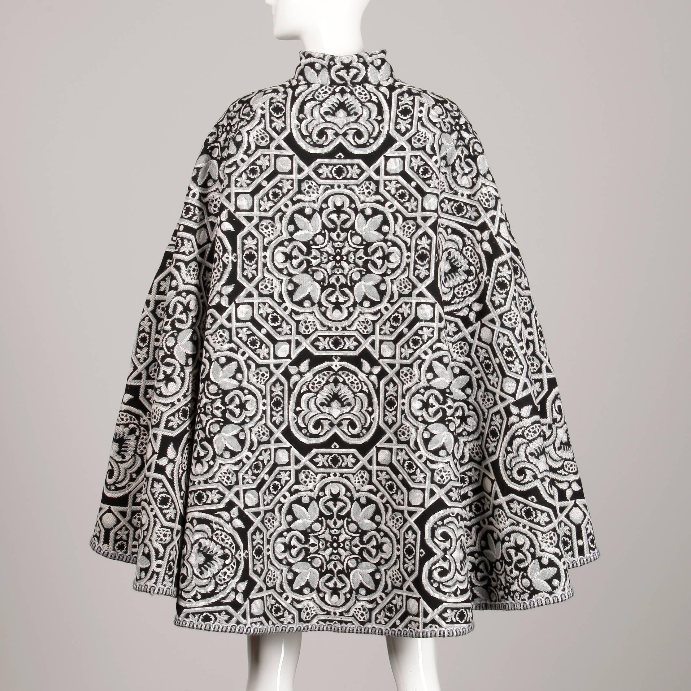 Incredible Spanish-made vintage tapestry cape coat in a black, white and gray weave. Unlined with front tie closure. Free size. The total length measures 37.5