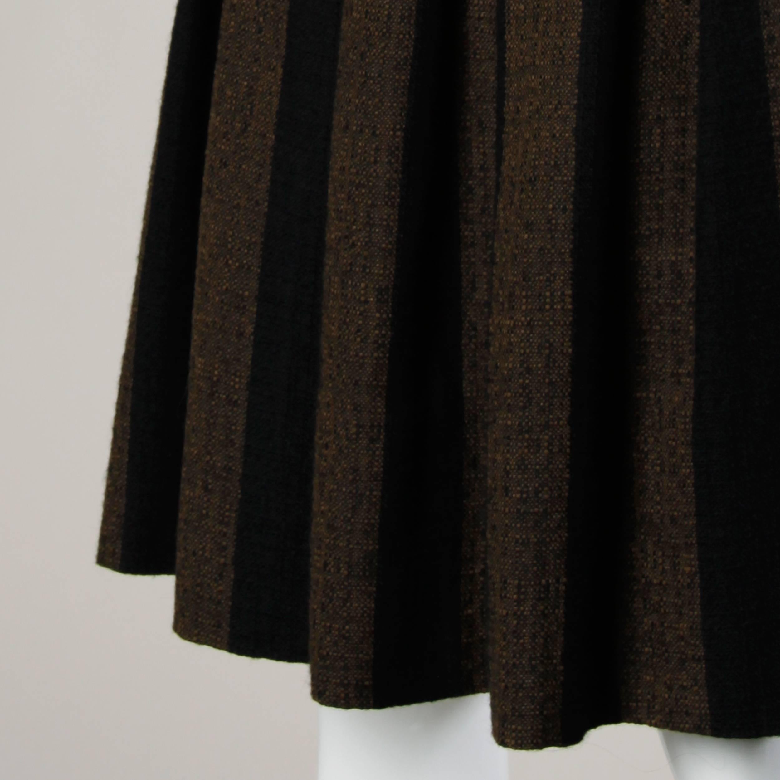 Vintage 1960s brown and black soft woven wool skirt with box pleats.

Details:

Unlined
Back Button and Back Metal Zip Closure
Marked Size: Not Marked
Estimated Size: XS
Color: Brown/ Black
Fabric: 100% Wool 
Label: Graff
