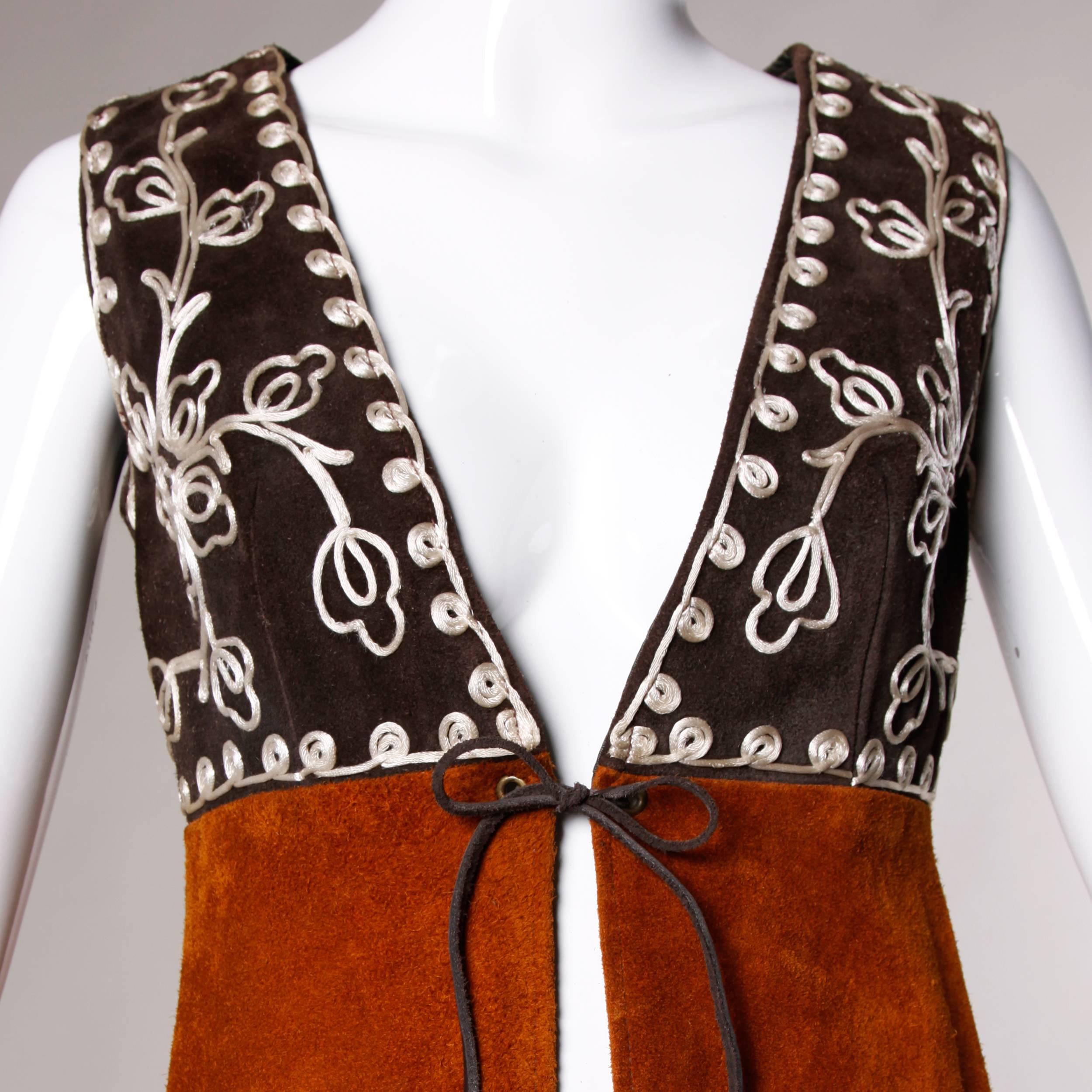 Phenomenal long vintage two tone suede vest with a back kick pleat and hand whip stitch detailing. White cord embroidery and single tie closure at the front.

Details:

Fully Lined
Front Tie Closure
Marked Size: Not Marked
Estimated Size: