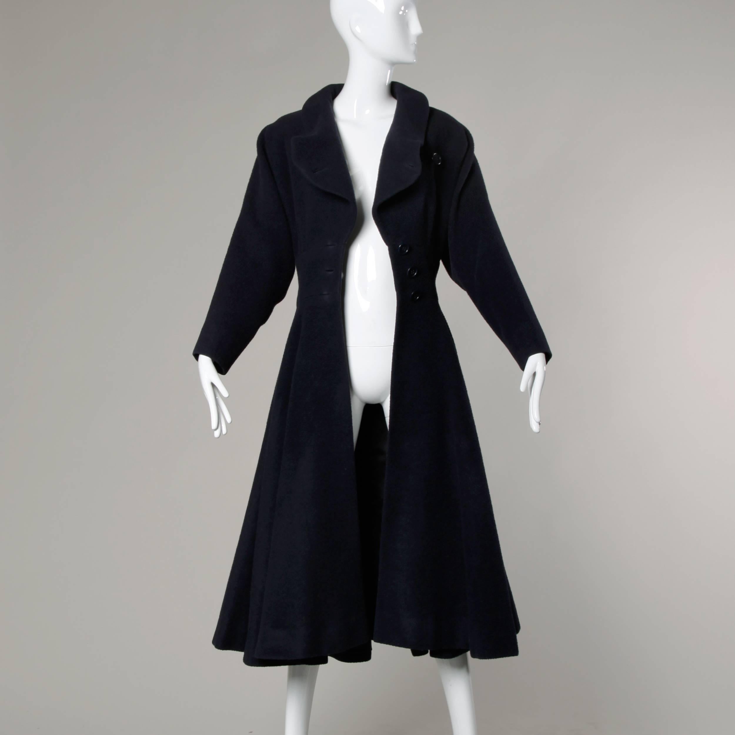 A very rare 1940s Traina-Norell swing coat with a massive sweep in remarkable condition. This coat was a very early Norman Norell piece during the years he spent collaborating with designer Teal Traina. 

In gorgeous deep navy blue wool, the coat