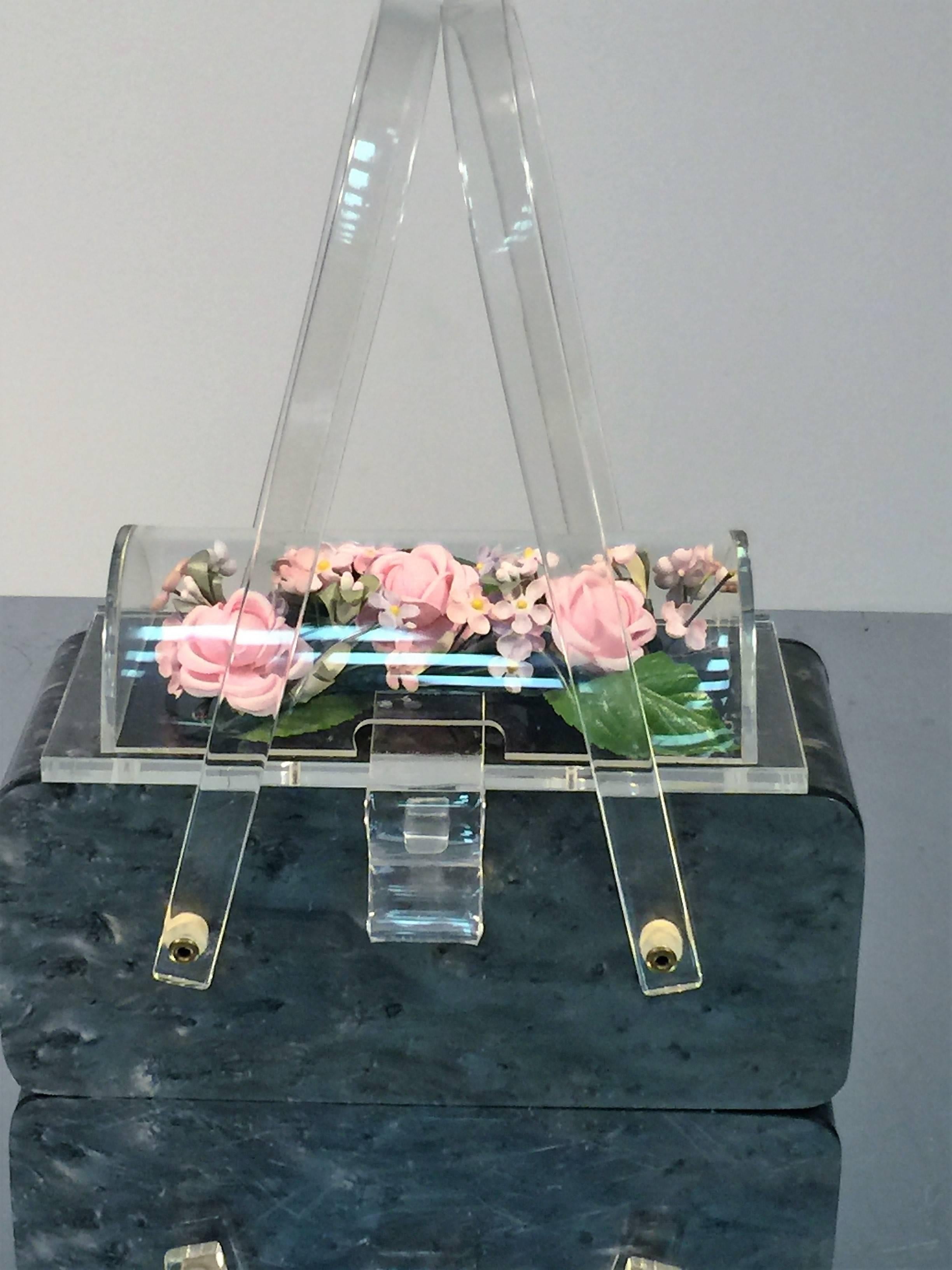 Beautiful Gray Bodied Lucite Handbag with Clear Curved Lucite Dome that encases Pink Silk Flowers with Green Leaves.Designed in the 1950's this is a real showstopper that is perfect for the summer to wear with a great summer dress.In excellent neo