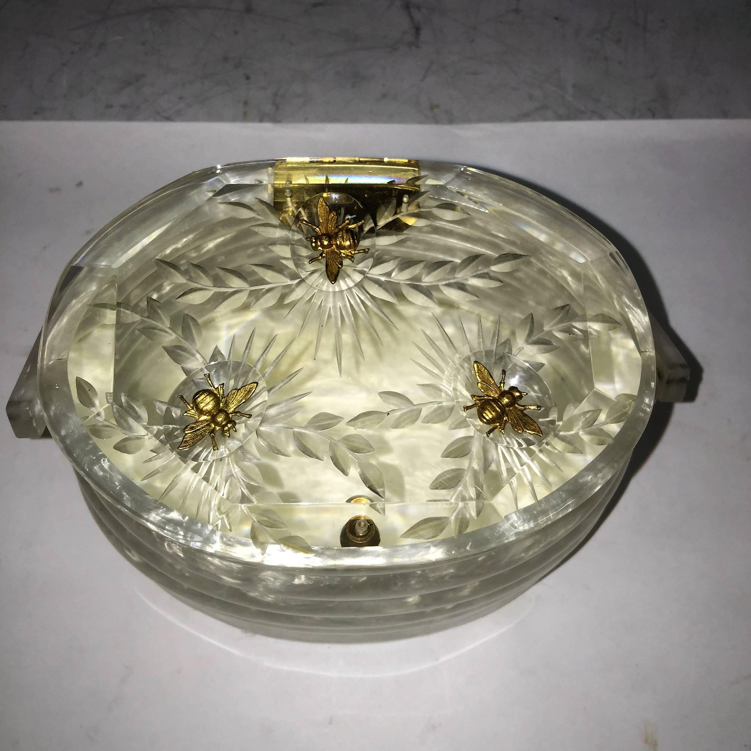 Exceptional Pearlized White Beehive Lucite Handbag Made in the 1950's in the United States.Wonderful Design of a Beehive with Clear Carved Lucite Top with  Beveled Sides and Carved Flower Designs accented by Goldtone Flying Metal Bees.In Perfect