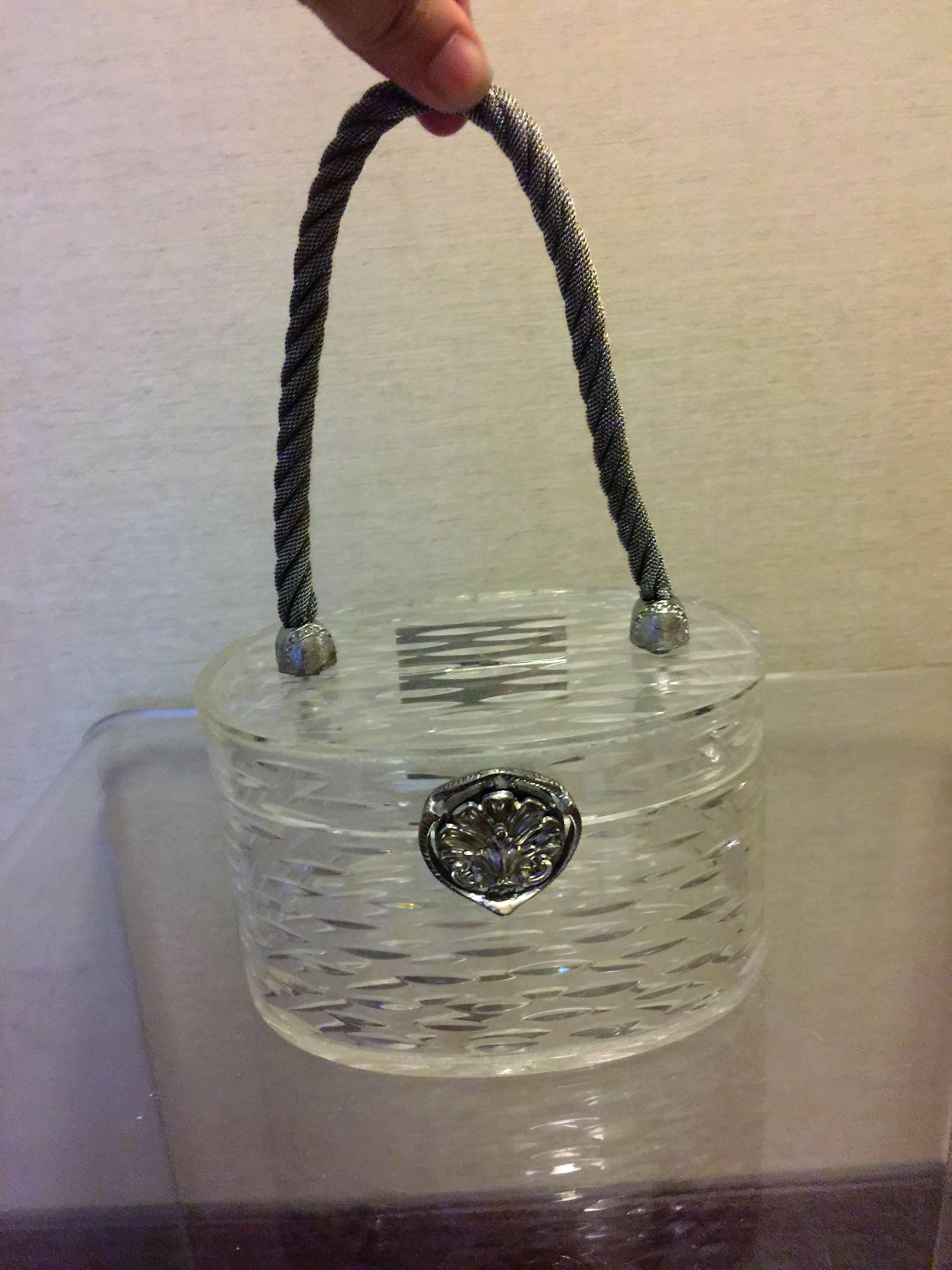Beautiful and Petite Clear Carved Oblong Shaped Lucite Handbag designed by Wilardy.Perfect for an Evening Out.In Perfect Condition signed Wilardy on the Inner Chrome Hinge.The Measurements of the Handbag without the Handle are 3 1/2