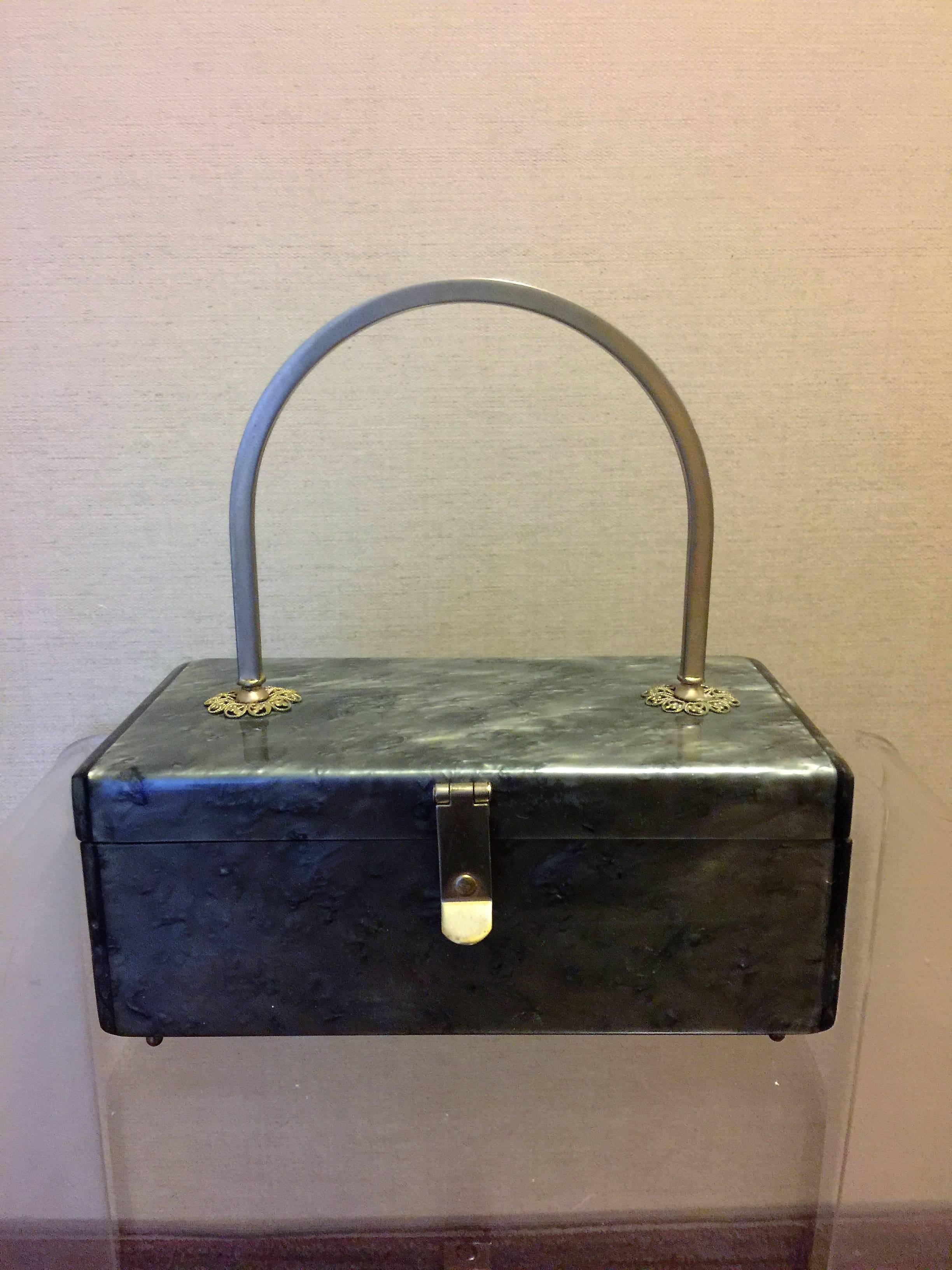 Modern Rectangular 1950's Lucite Handbag with Brass Filagree Accents and Handle.Original Mirror inside with Brass Snap Closure.Designed by Toro.The Measurements of the Handbag is 3 1/4