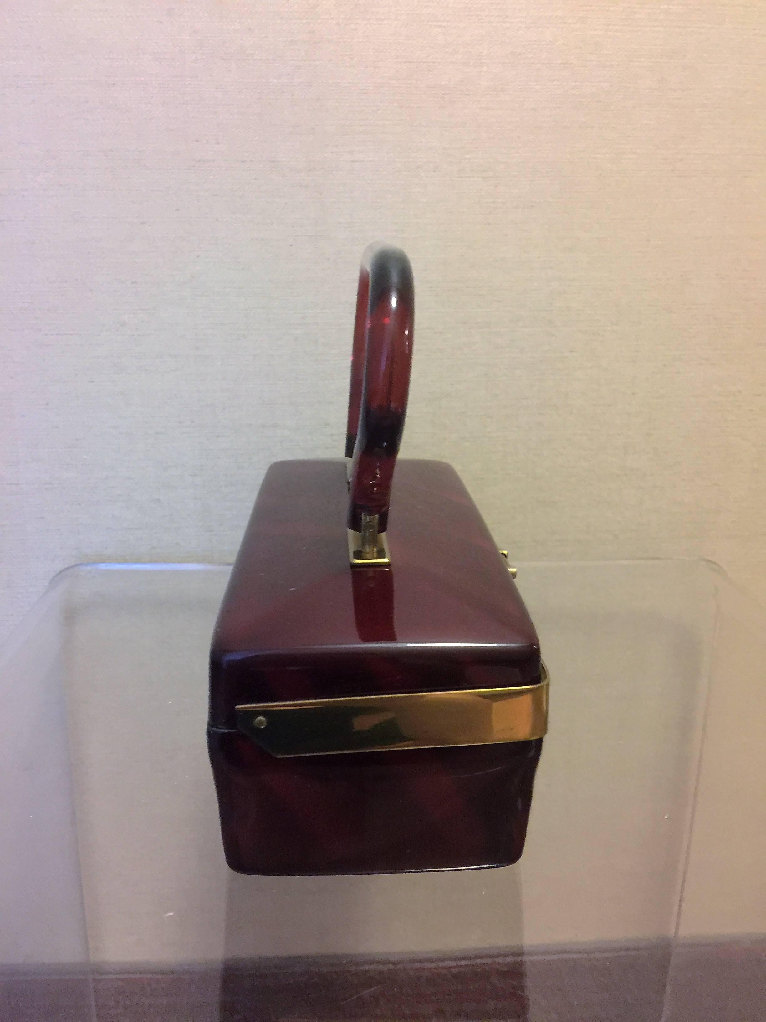 Great Shaped Deep Caramel Faceted Top Lucite Handbag with Red Caramel Handle.Sleek Modern Design with Polished Goldtone Brass Trim and Clasp designed by Dorset-Rex 5th Avenue in the 1950's.The Measurements of the Handbag without the Handle is 3 1/8