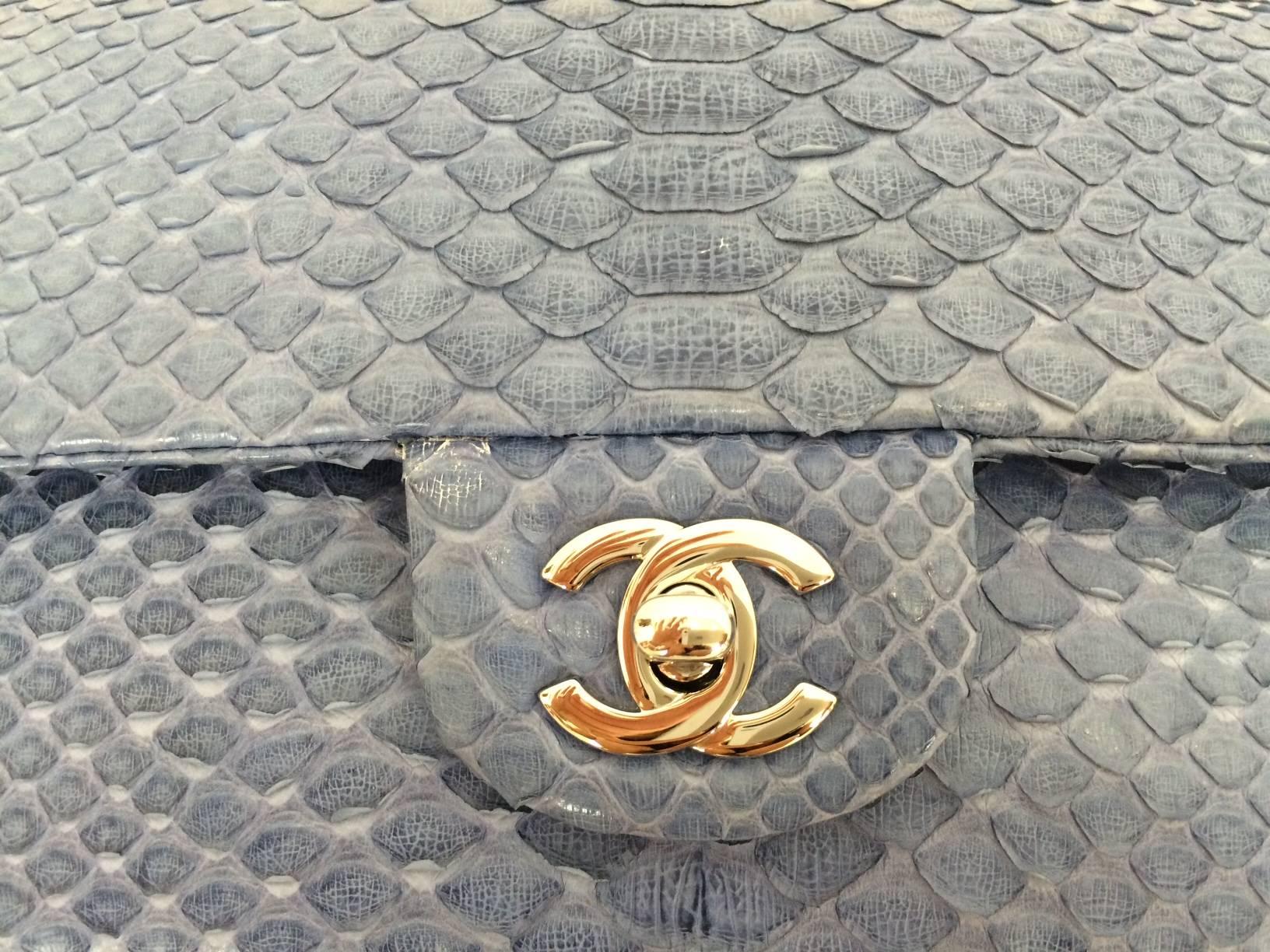 Chanel mini powder blue python bag with silver chain strap interlaced with python and CC turnlock. Back slip pocket. Denim blue leather lined interior with one slip pocket and one zip pocket. Delivered with Chanel original authenticity card,