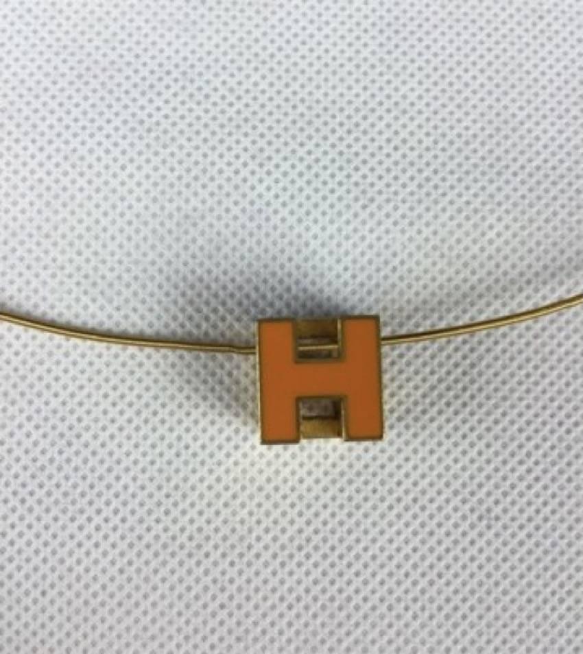 Cage d'H Pendant Hermès in gold holding a orange enamelled cubic H 
Good condition.

Total lenght : 43 cm
H dimension : 1.2 x 1.2cm