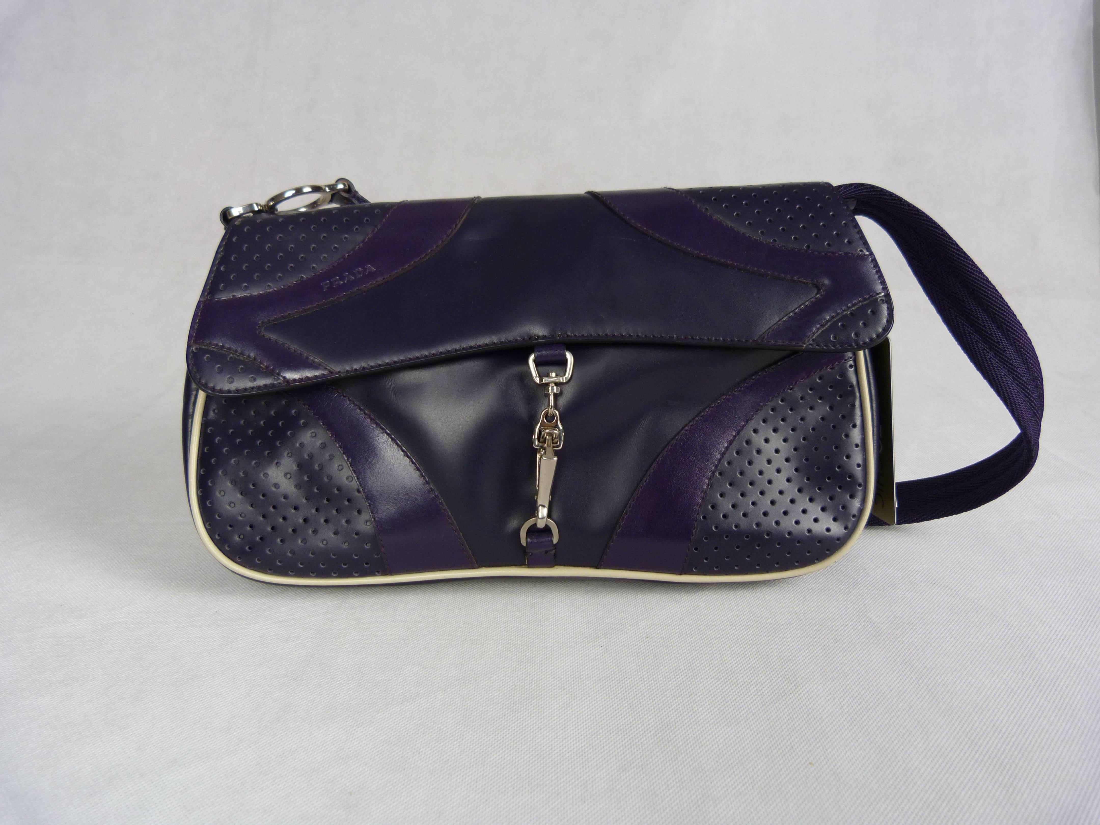 Black and purple partially drilled leather bag, handle shoulder strap in painting dyes purple, a patch pocket outside, a clasp by pressure and hook.

Inside in bearing the initials painting, a zipped pocket.