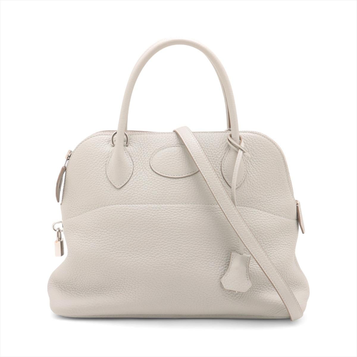 Le sac à bandoulière Hermès Bolide 31 Taurillon Clémence en gris perle est un accessoire intemporel et élégant, réalisé en cuir Clémence souple et doux. Sa silhouette structurée est complétée par des bords arrondis et une quincaillerie subtile en