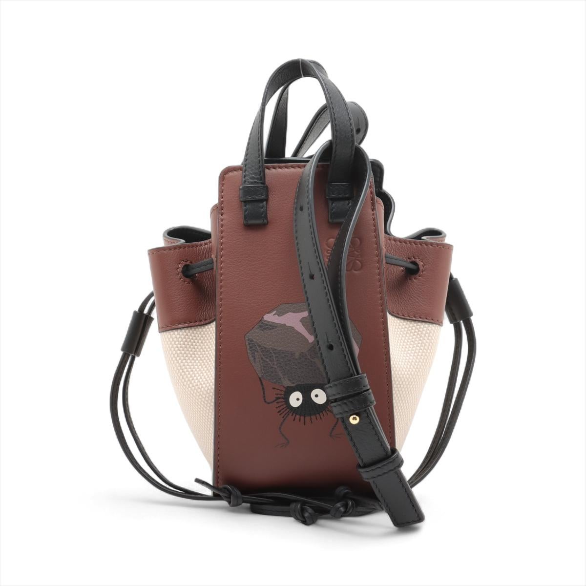 Die Loewe x Studio Ghibli Hammock Drawstring Mini Leather Two-Way Shoulder Bag Brown x Beige ist eine charmante Verschmelzung des innovativen Designs von Loewe und der skurrilen Geschichten von Studio Ghibli. Diese aus geschmeidigem Kalbsleder