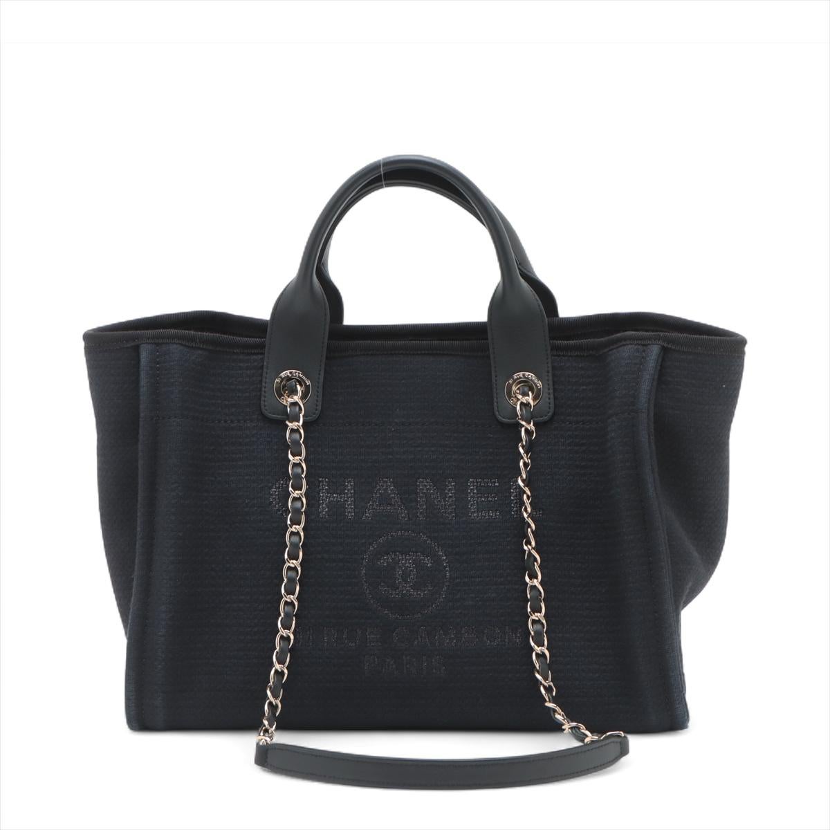 Die Chanel Deauville MM Canvas Chain Two-Way Tote Bag in Marineblau ist ein schickes und vielseitiges Accessoire. Sie ist aus strapazierfähigem Canvas gefertigt und trägt auf der Vorderseite den kultigen Schriftzug 