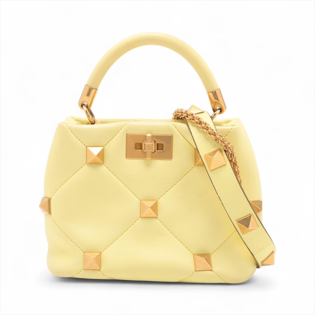 La borsa a spalla in pelle con borchie di Valentino Garavani in giallo è un pezzo di grande effetto realizzato in pelle lussuosa, che sfoggia le borchie oversize tipiche del marchio. Presenta una silhouette strutturata con una sicura chiusura