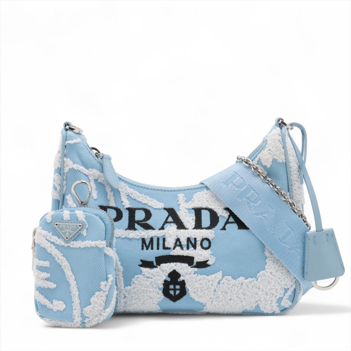 Die Prada Embroidered Floral Re-Edition Canvas Shoulder Bag in Blau ist ein schickes und elegantes Accessoire aus strapazierfähigem Canvas, das mit einer zarten Blumenstickerei verziert ist. Der geräumige Innenraum bietet reichlich Platz für die