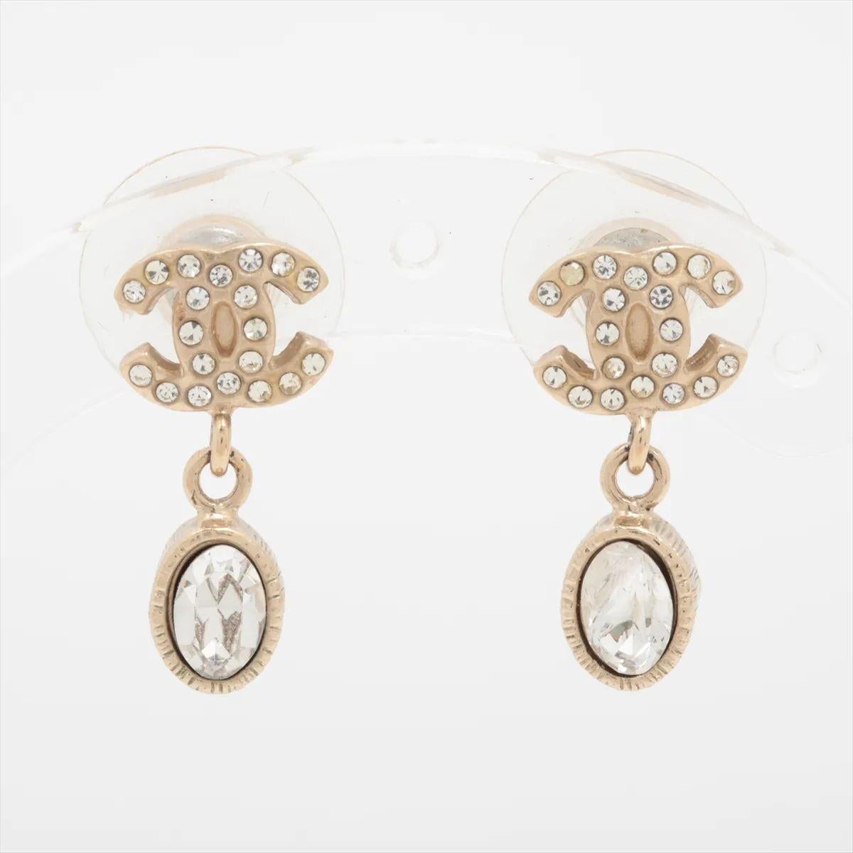 L'orecchino Chanel CC Logo Rhinestone Drop Stud Earring emana un'eleganza senza tempo con un tocco di brillantezza. Caratterizzata dall'iconico logo CC a incastro, la borchia è impreziosita da strass scintillanti che catturano la luce. Un delicato