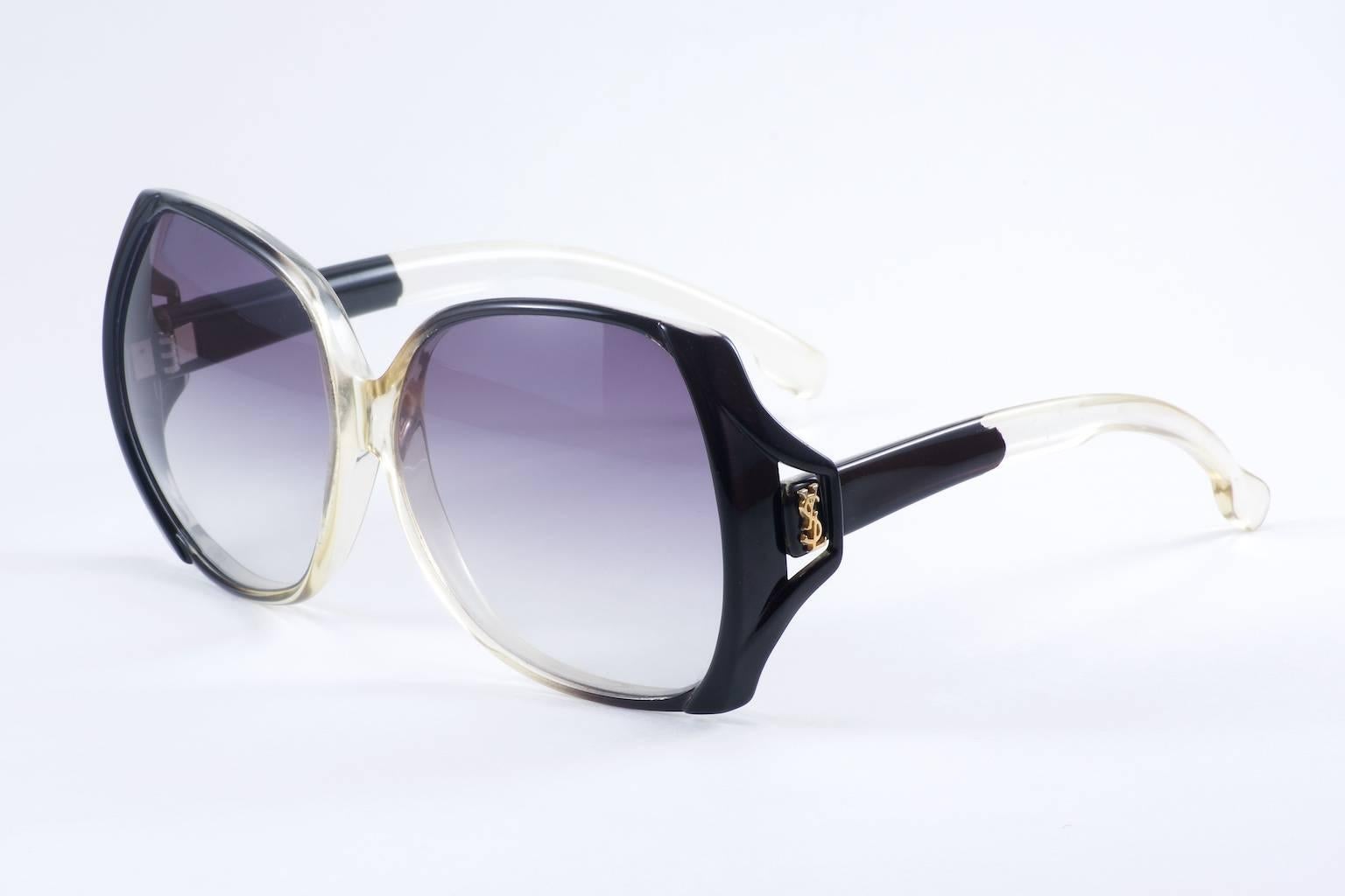 Fabulous rare YSL square sunglass.
Unique cutout on side of the
frame front displays subtle YSL initials.
Black edges fading into an off clear center.
Sophisticated and versatile.
Complements will follow you.
Fitted with new UV/UVA