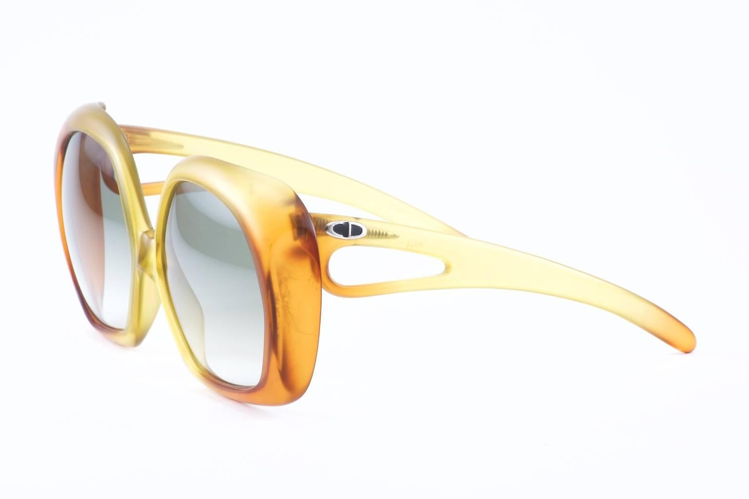 1970's Personified in this Fabulous oversized Amber Sunglass by Christian Dior. Warm glow of Matte Amber fading from the outside edge into a soft golden yellow at the bridge. 

The temple has an interesting curve with a cutout near the frame
