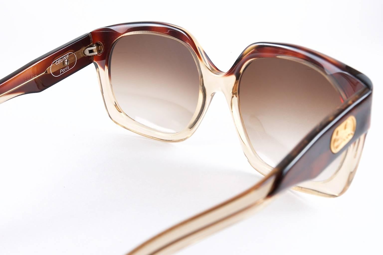 Beautiful pair of vintage Céline Paris sunglasses dating to the mid to late 1970s. Oversized square shaped frames with gradient brown lenses, complimenting the dark mahogany acetate two tone coloured frames. Distinctive gold engraved logo Céline