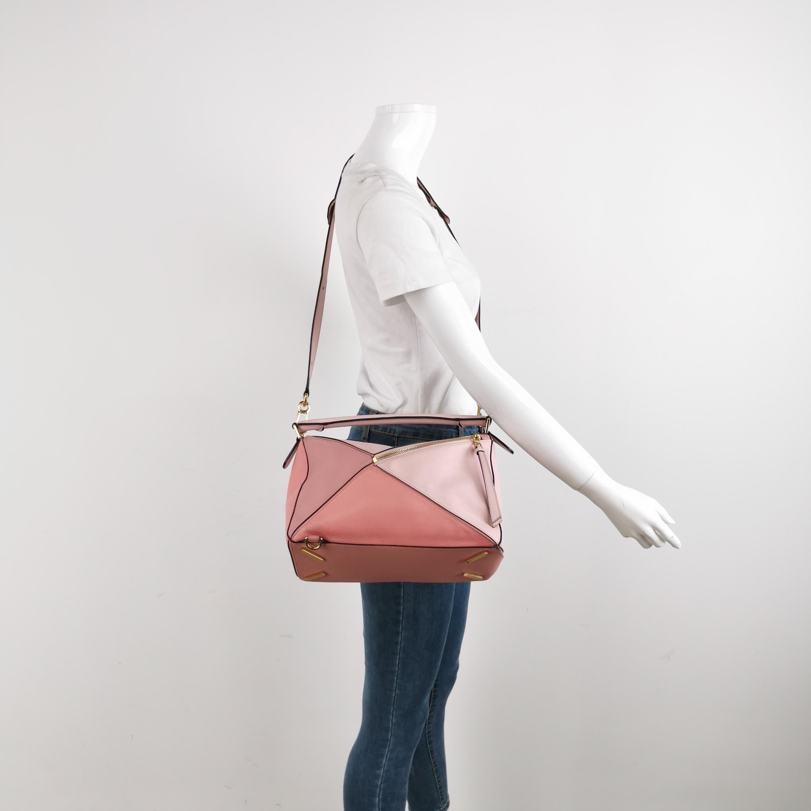 Die Puzzle-Tasche von Loewe ist ein zeitloser Klassiker mit Kultcharakter. Die Tasche ist aus geschmeidigem Kalbsleder gefertigt und mit silbernen Beschlägen und den charakteristischen Origami-Einsätzen versehen. Sie ist vielseitig und