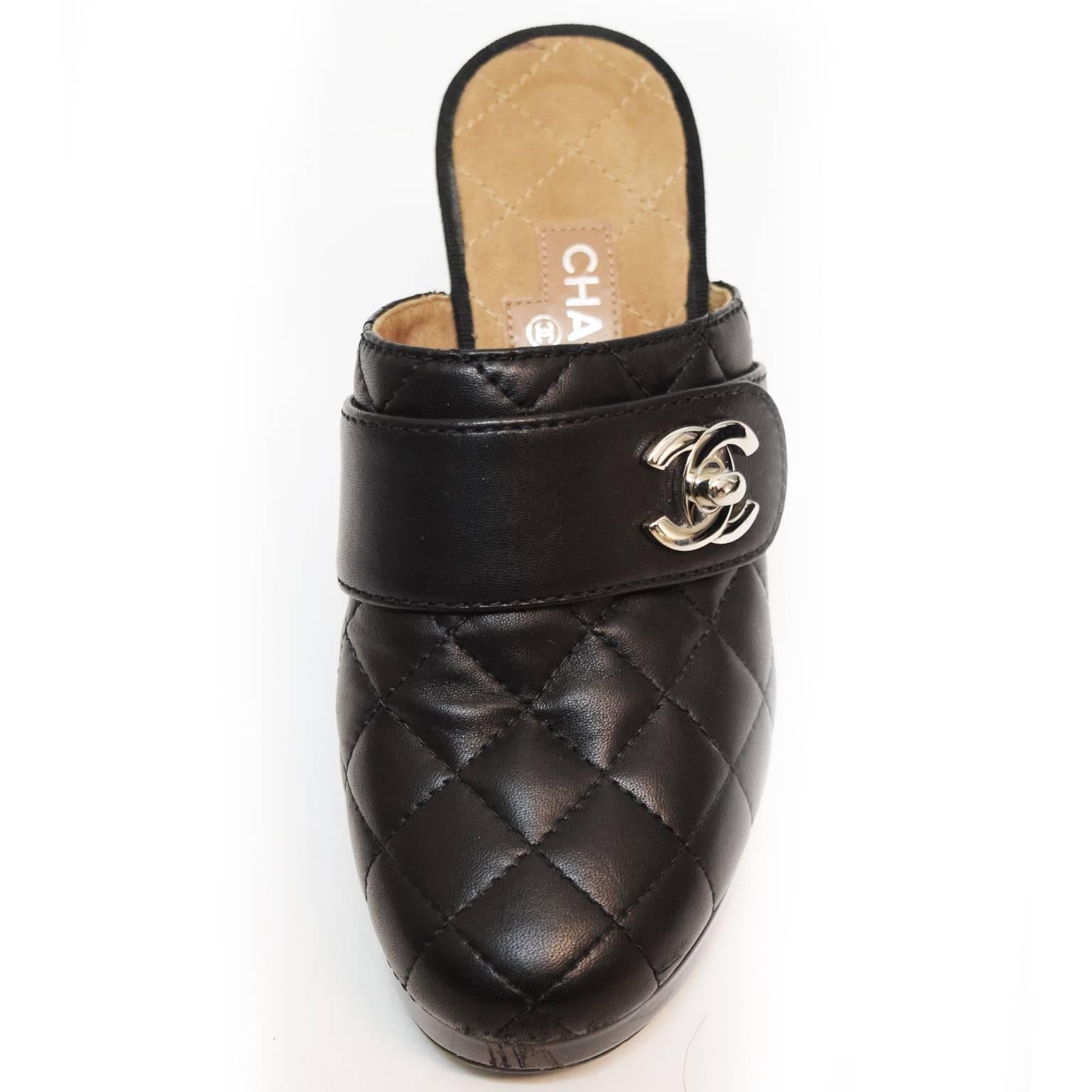 These classic Chanel Clog are made with soft lambskin leather in a quilted stitched pattern in consistency with Chanel's statement quilted handbags. Strap detail on the toe box of the shoe with the Chanel logo turn lock in silver. Wooden heel