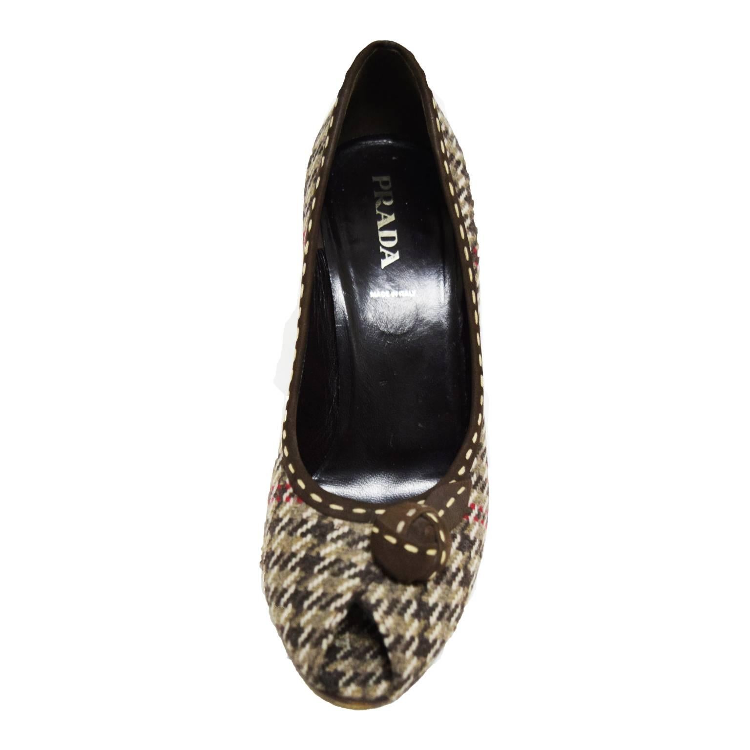 These unique Prada wool pumps are incased in wool with a neutral houndstooth print. On the upper is a suede floret with ivory stitching for a playful contrast.  