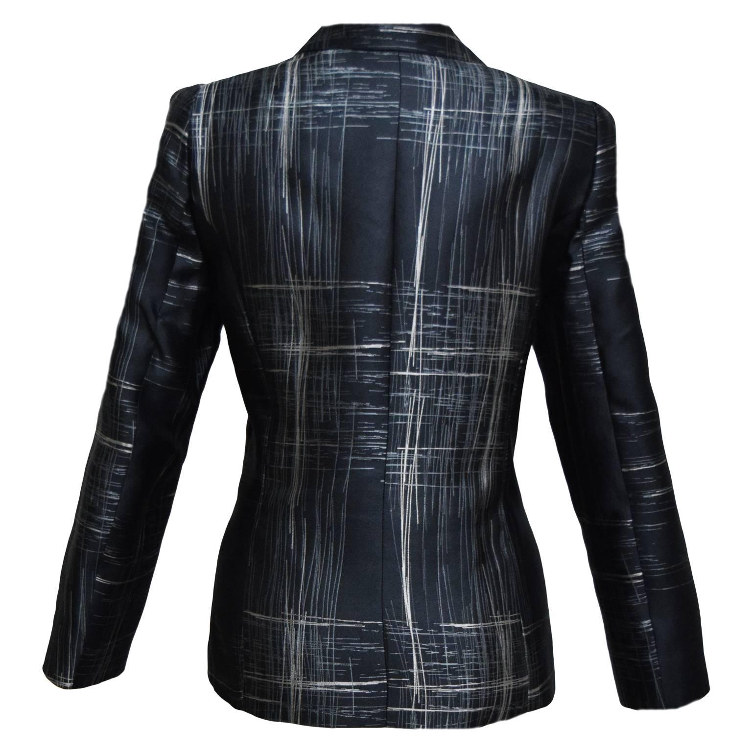This amazing sophisticated Armani blazer is made from 100% silk with black, grey, and iridescent white, abstract striped print. It is single breasted, has pockets, darts, and is fully lined.