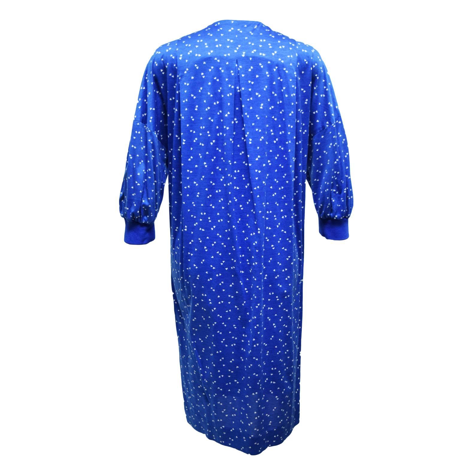 This Akris shirt dress is 100% blue and white heart printed cotton, and has iridescent pearl like heart shaped button front embellishments. The sleeves are shirt bat winged sleeves and the dress has pleating detailing for shape.   