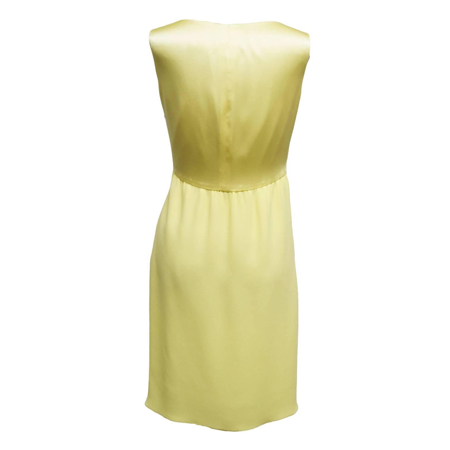 This beautiful dress by Valentino is made of 100% muted yellow silk, and has a knotted sweetheart neckline that is very slimming. The skirt of the dress is a silk chiffon and is sheath like. Fully lined. 