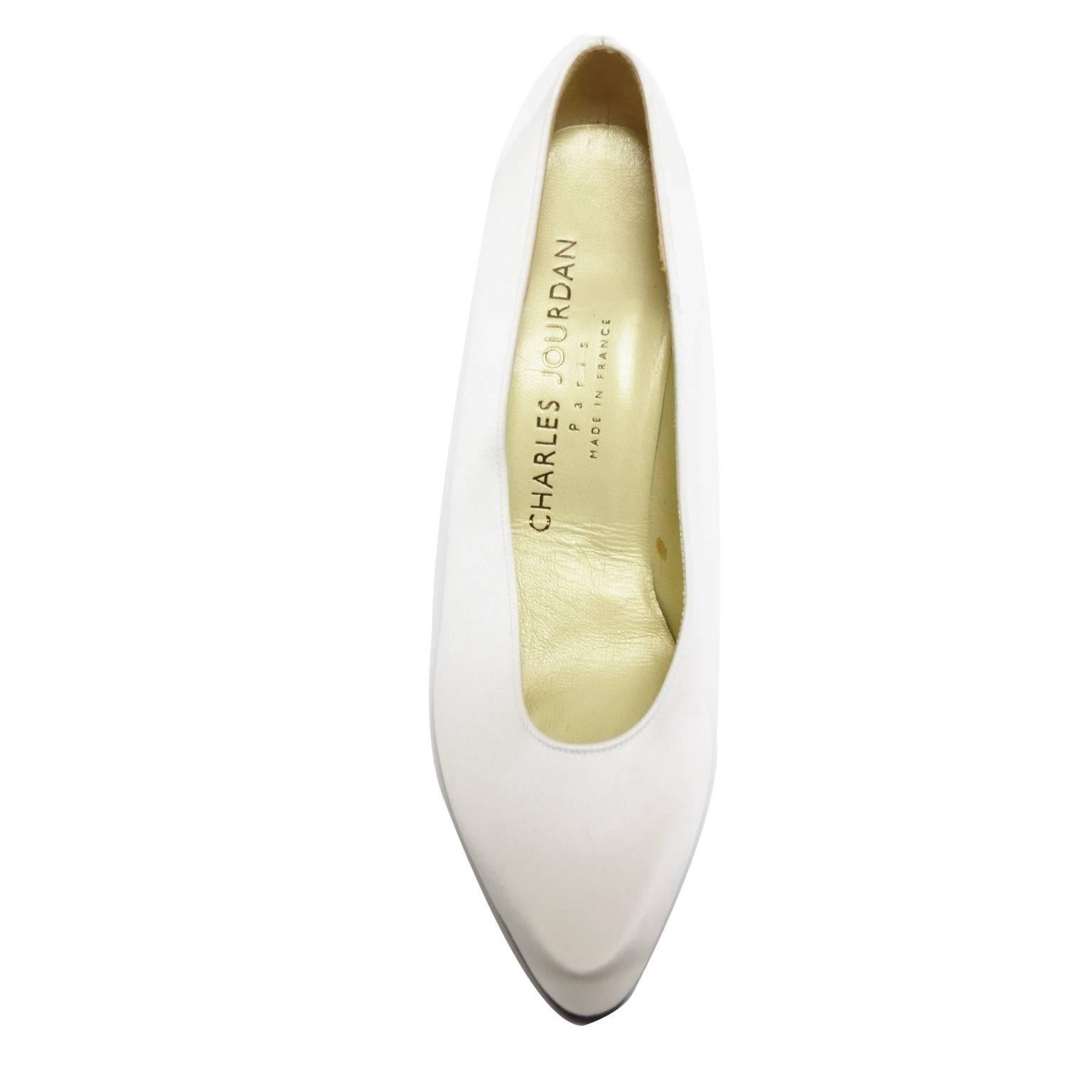 These Charles Jourdan pumps are engulfed in rich ivory satin that covers the upper, sole, heel. The heel is a spanish heel shape and the sole is brand new black and wooden.  