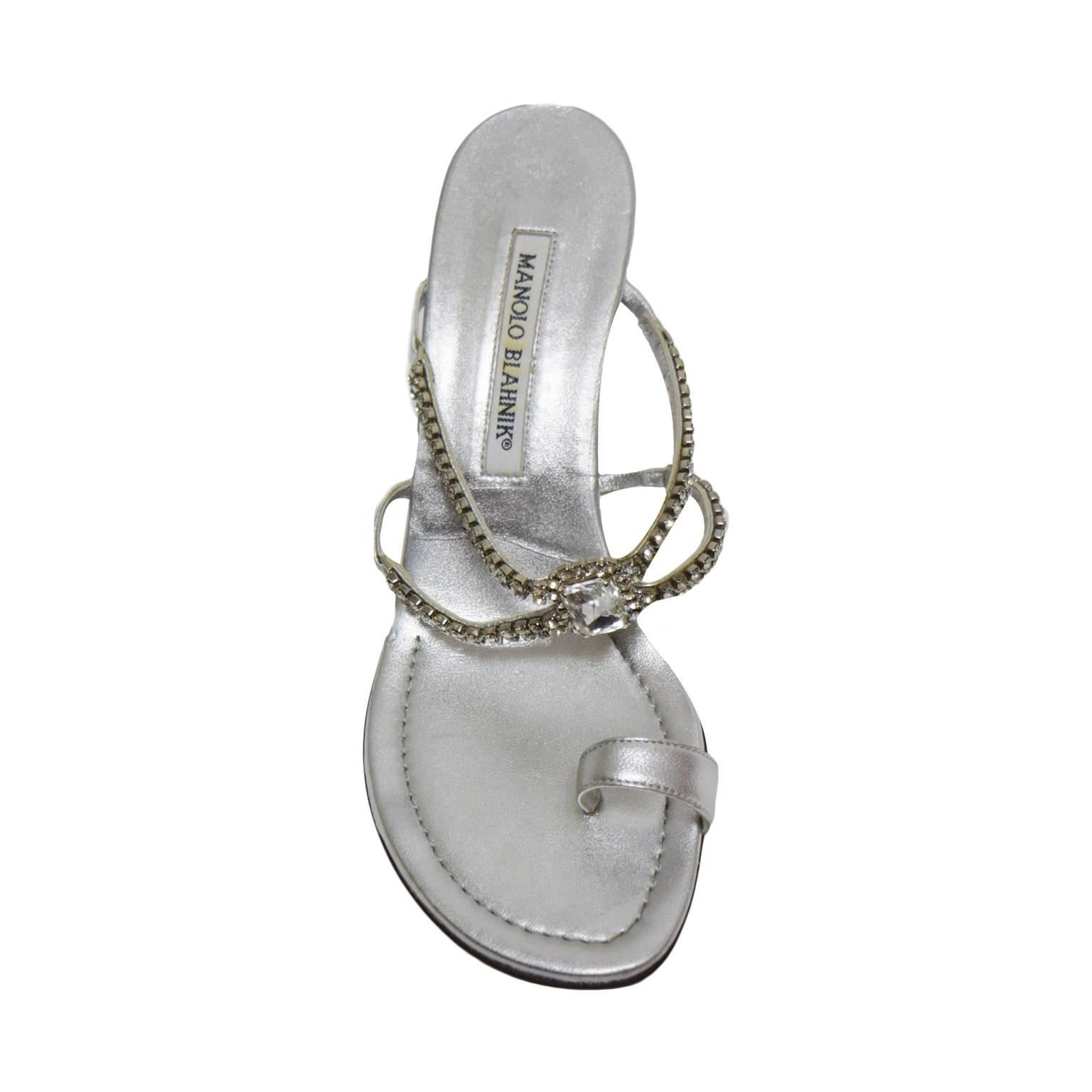 This elegant Manolo Blahnik sandals are perfect for any special occasions. The sole is made of metallic leather and the straps are lined in leather and are embellished with Swarovski Crystals and a square cut pendent. There is a toe loop for
