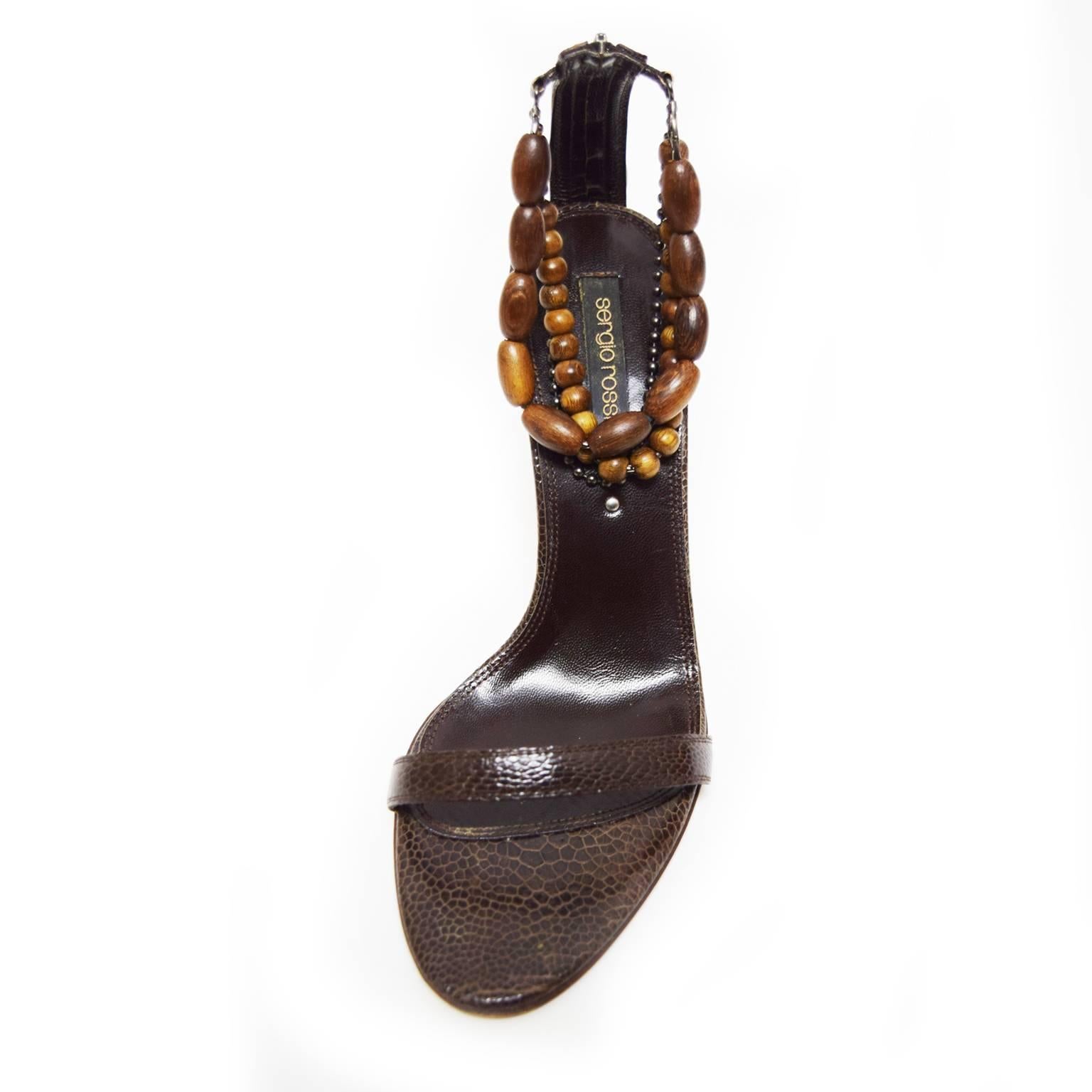 These one of a kind pumps designed by Sergio Rossi are to die for! Made out of rich deep brown reptile leather for the sole and toe strap upper, the ankle strap is embellished with multiple  wooden beaded straps, and has a zipped back.